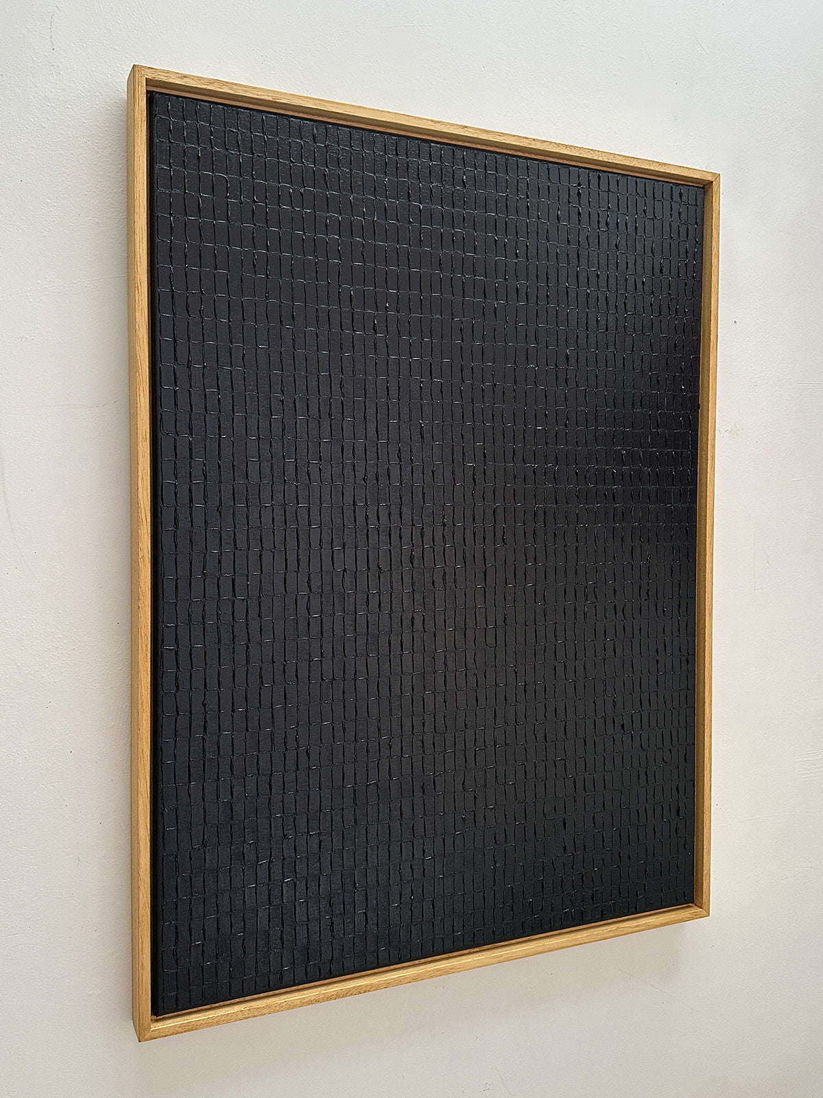 Textured black square painting with grid pattern by Roi Elmaliah