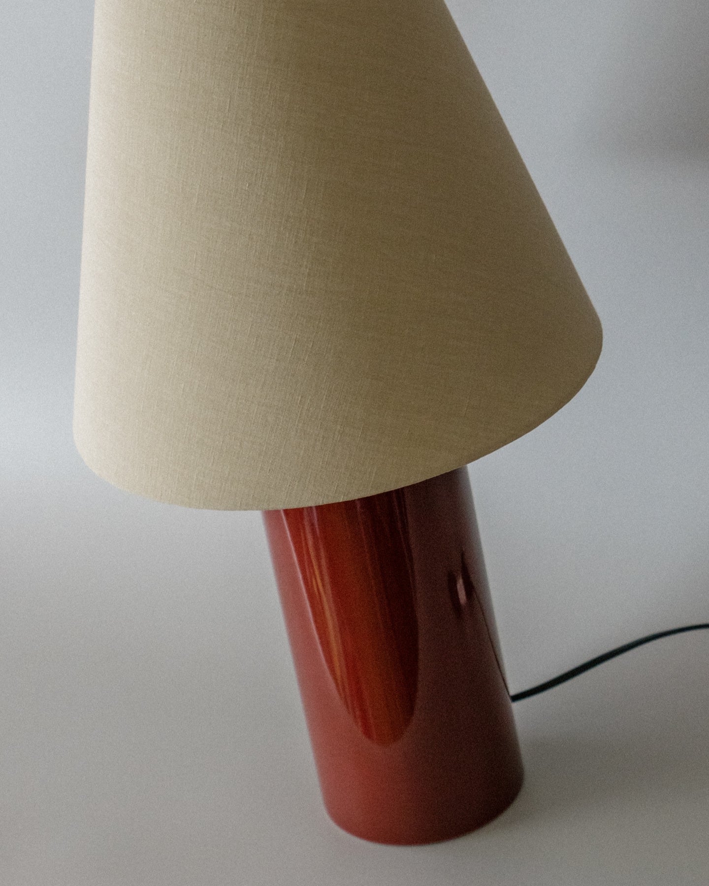 Giro" Table Lamp - Oxblood & Beige — side angle showing ceramic base and fabric shade