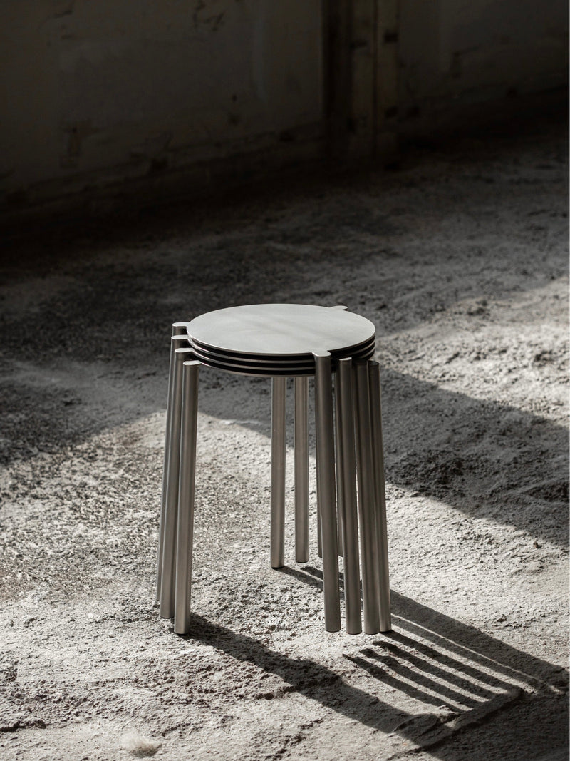 Stool - Isla x Paul Delrez - Stainless Steel — stacked stools on textured floor