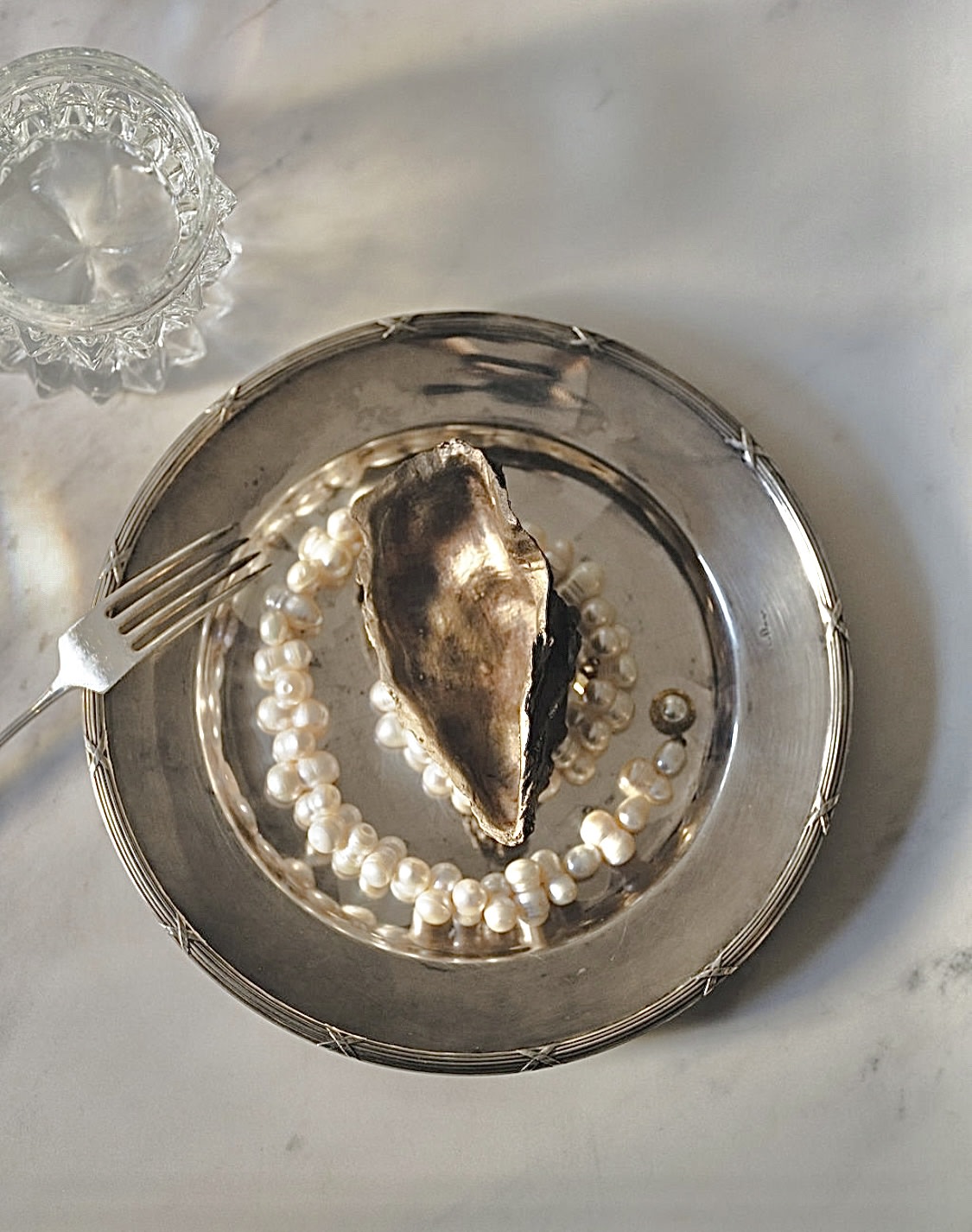 Pair of Bronze Oyster Sculptures — top view on silver plate with pearls