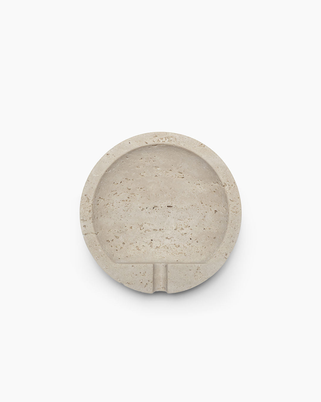 The JCL Ashtray in Travertine Stone features a round, beige design with a smooth surface and one cigarette notch, shown from above on a plain white background.