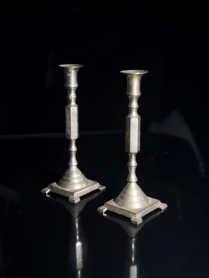 Silver plated candle holders — close-up of polished surface on black background