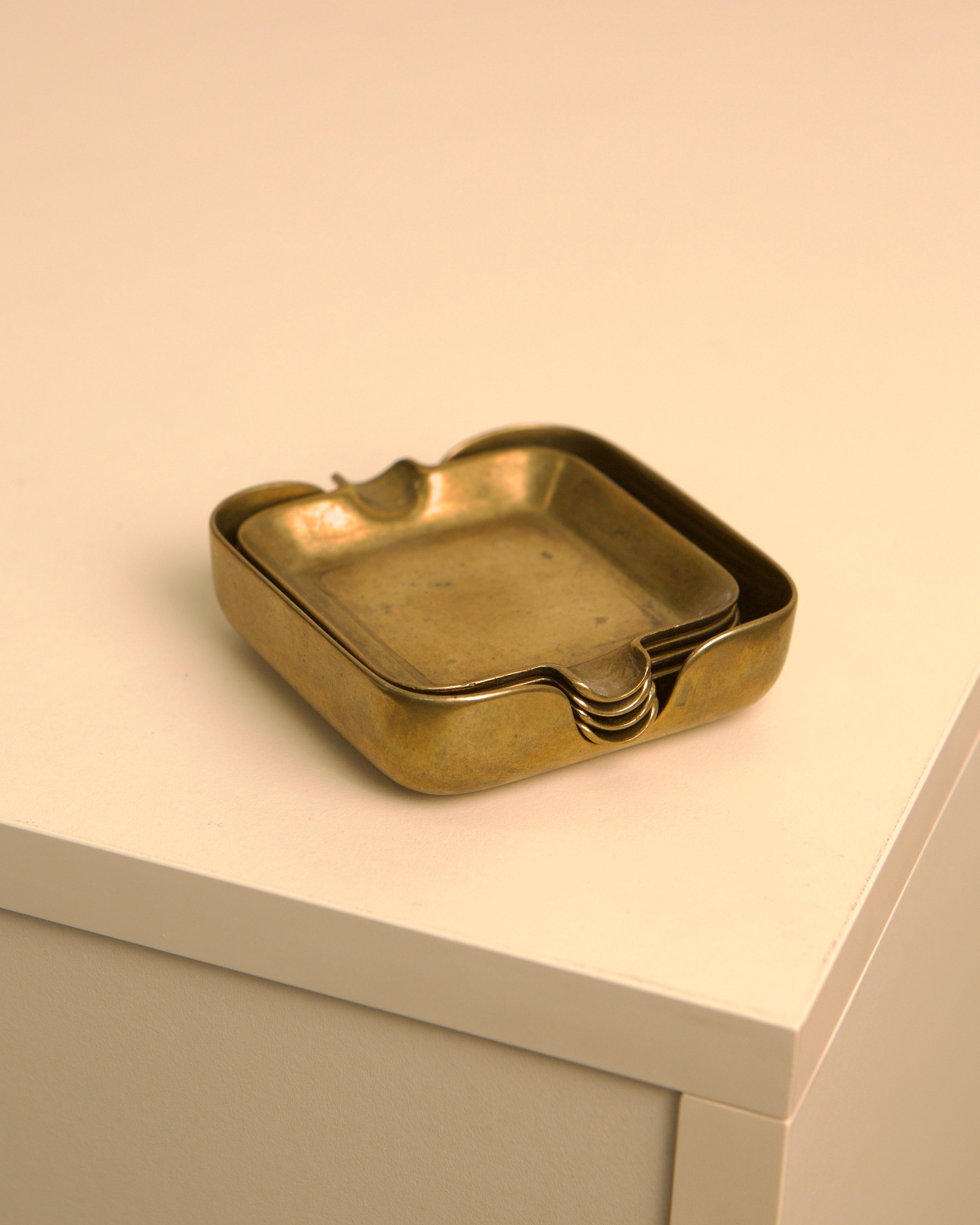 Brass ashtray detail showing curved edges and golden patina