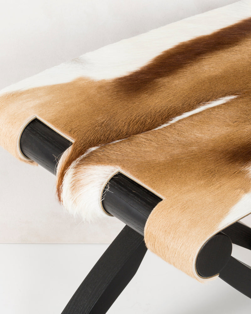 Antelope hide folding stool curved seat detail on black frame