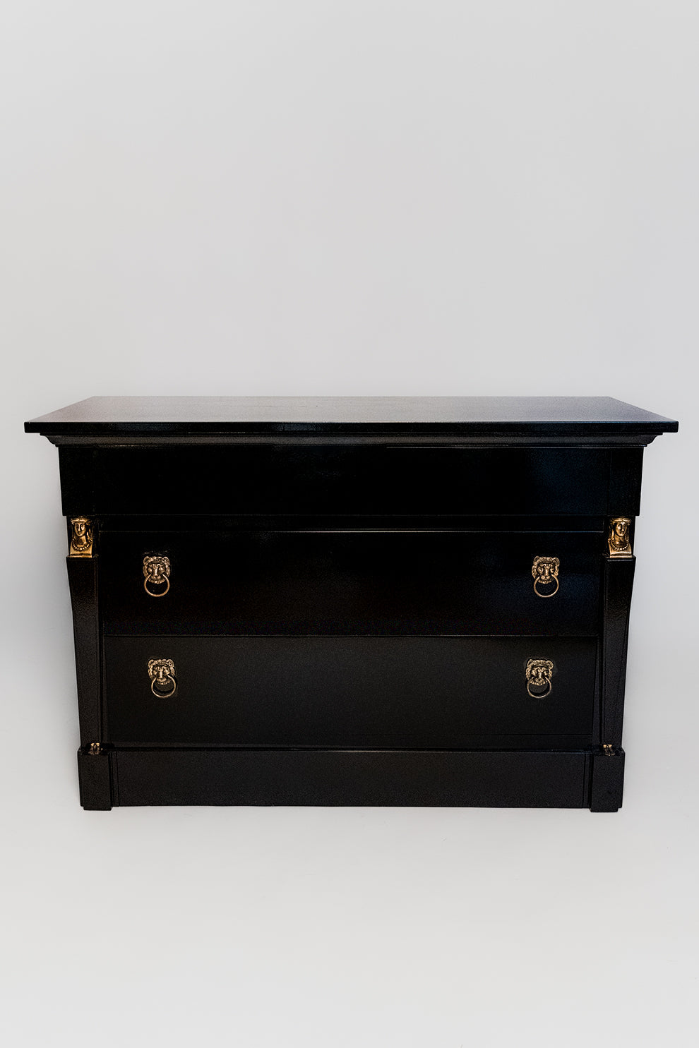 The 'Return of Egypt' Lacquered Drawers by Barracuda Interiors is a 19th c black chest with gold handles and accents. Set on a white background, its flat top and two drawers showcase Egyptian style elegance and timeless charm.