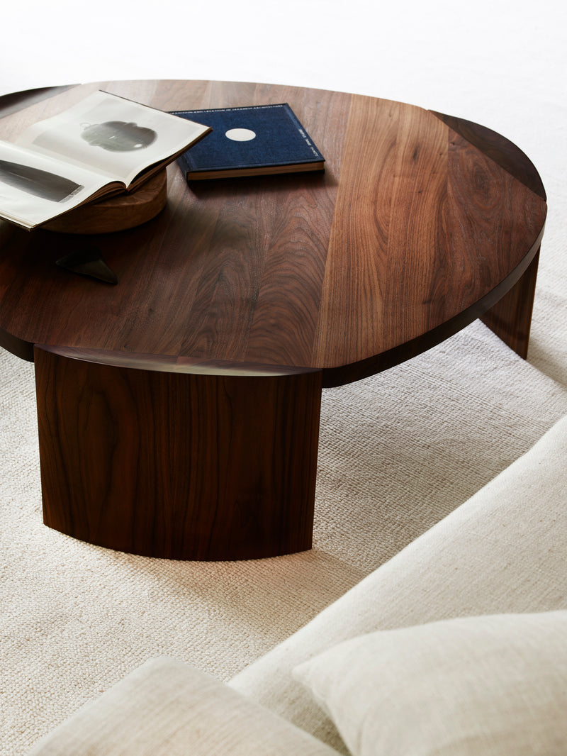 Pryn walnut round coffee table with books on neutral rug