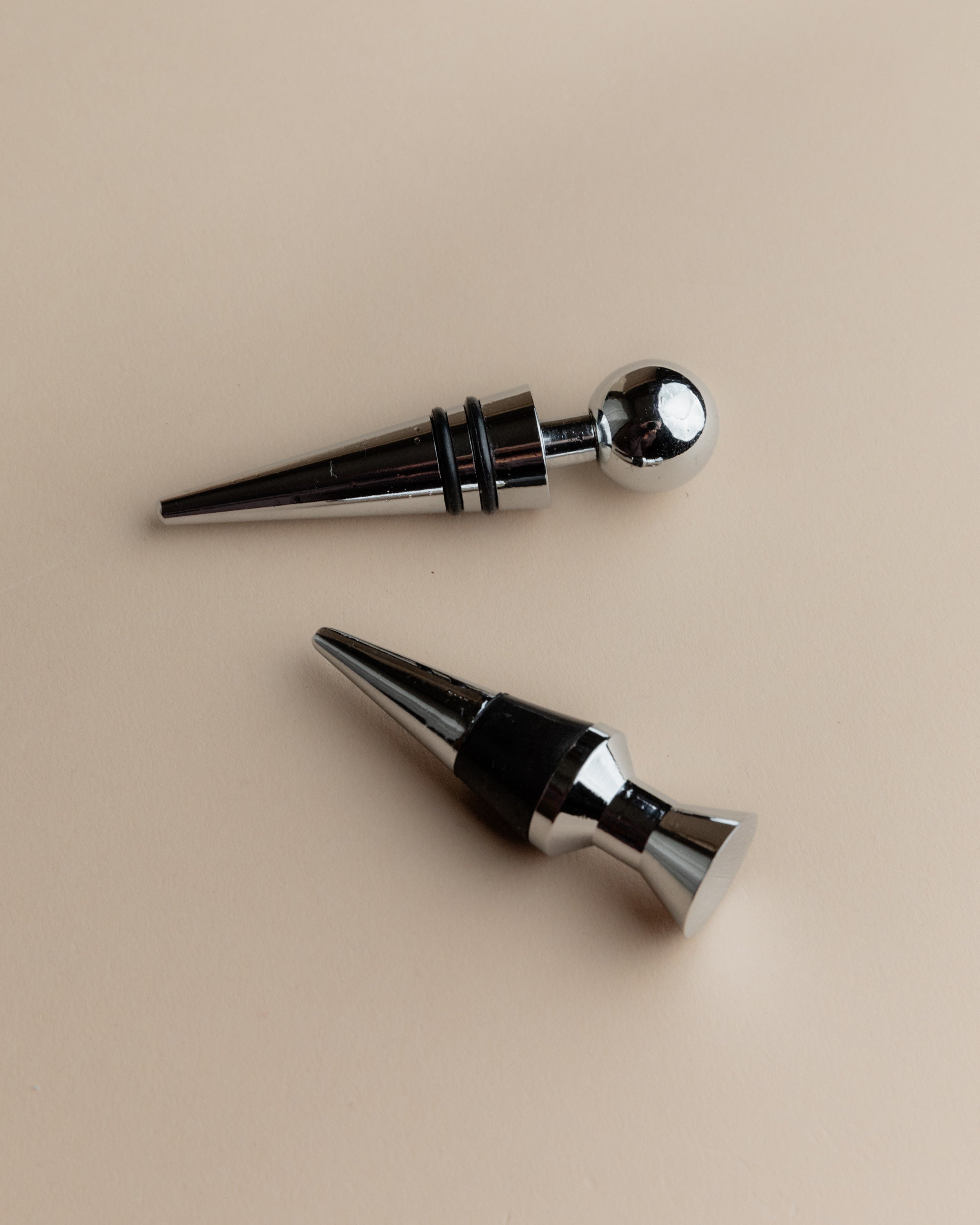 Vintage 1980s Bottle Stoppers Set of 2, Metal Geometric Conical Design Italy — close-up of polished metal surfaces