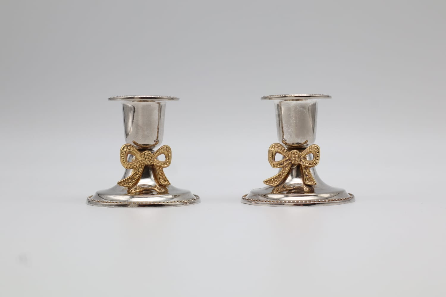Pair of Vintage Silver-Plated Candlesticks with Gilt Bow Accents — detail view