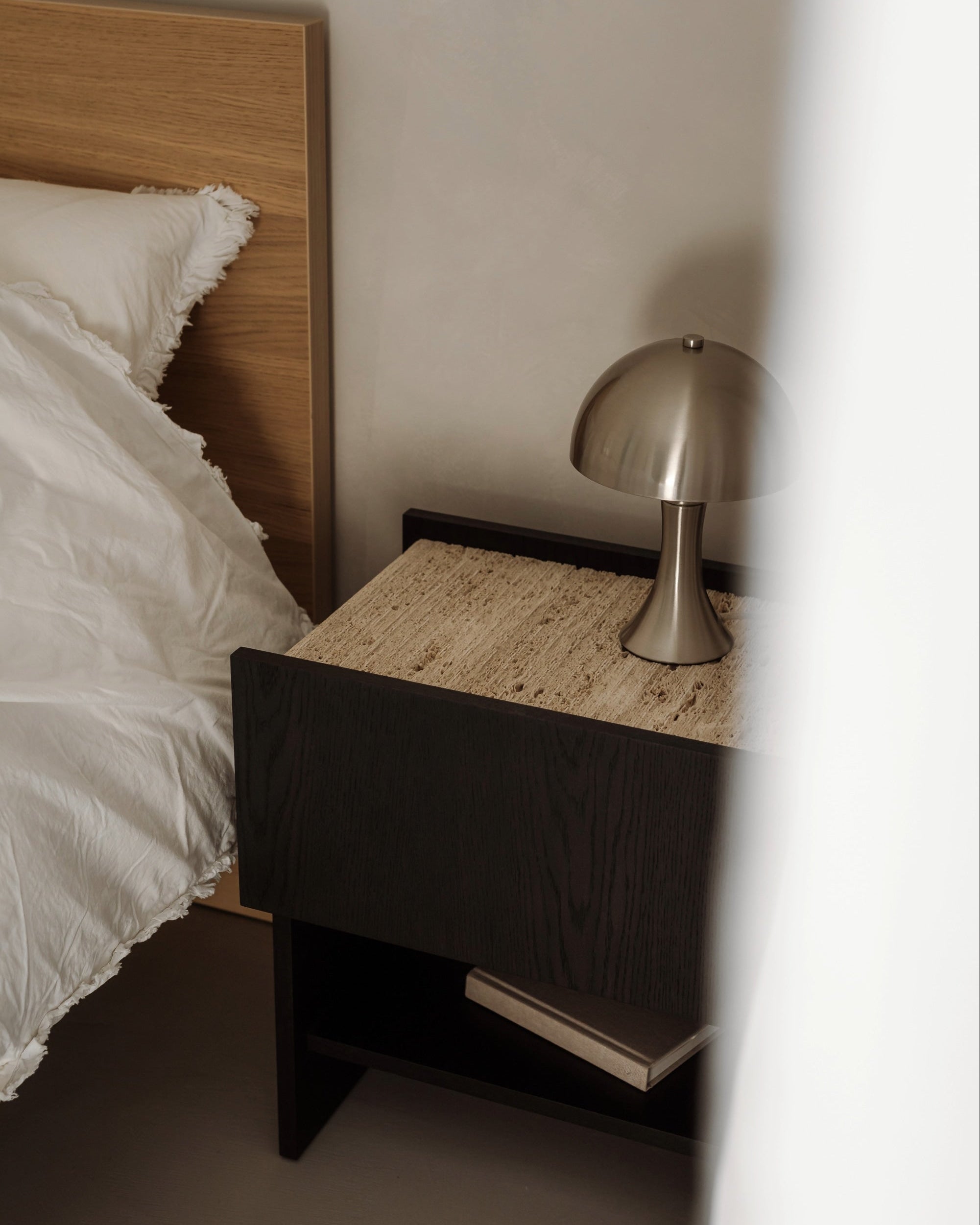 Dark wood NOTO nightstand with woven top and brass mushroom lamp