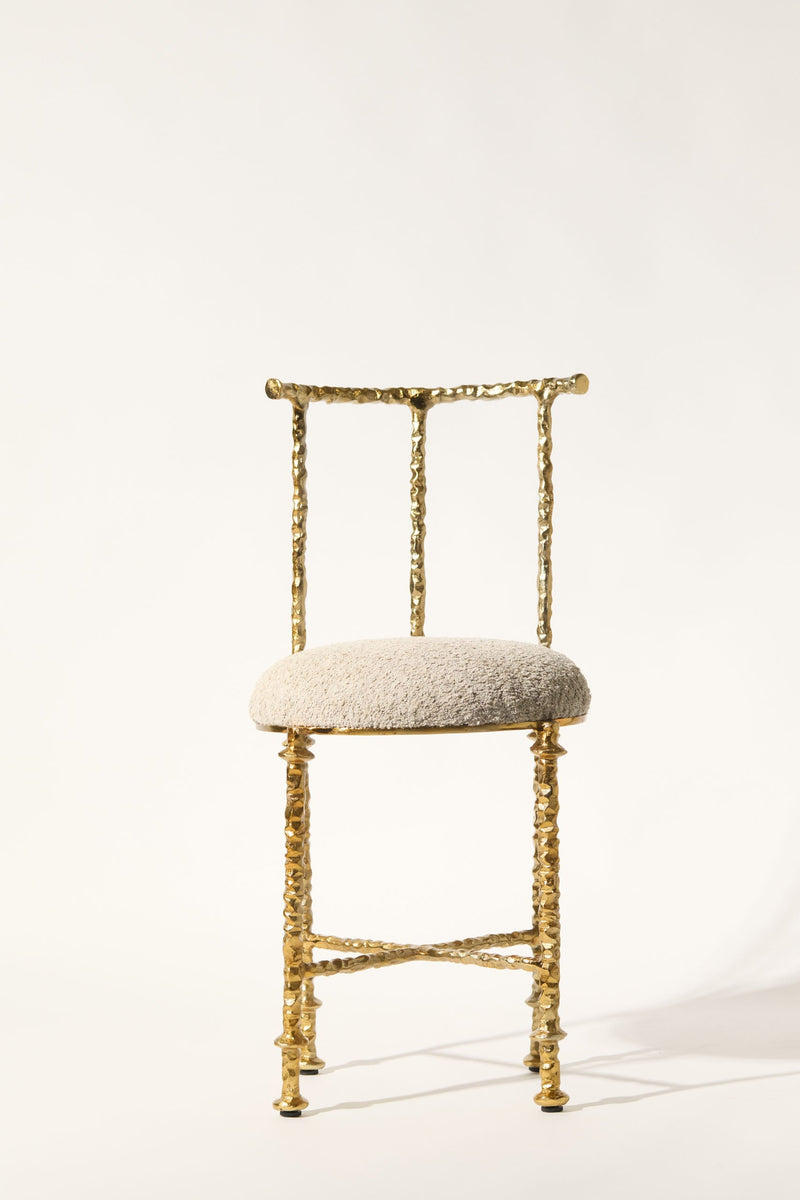 Aurelius' Cast Aluminum Chair — front view with textured gold finish and soft seat