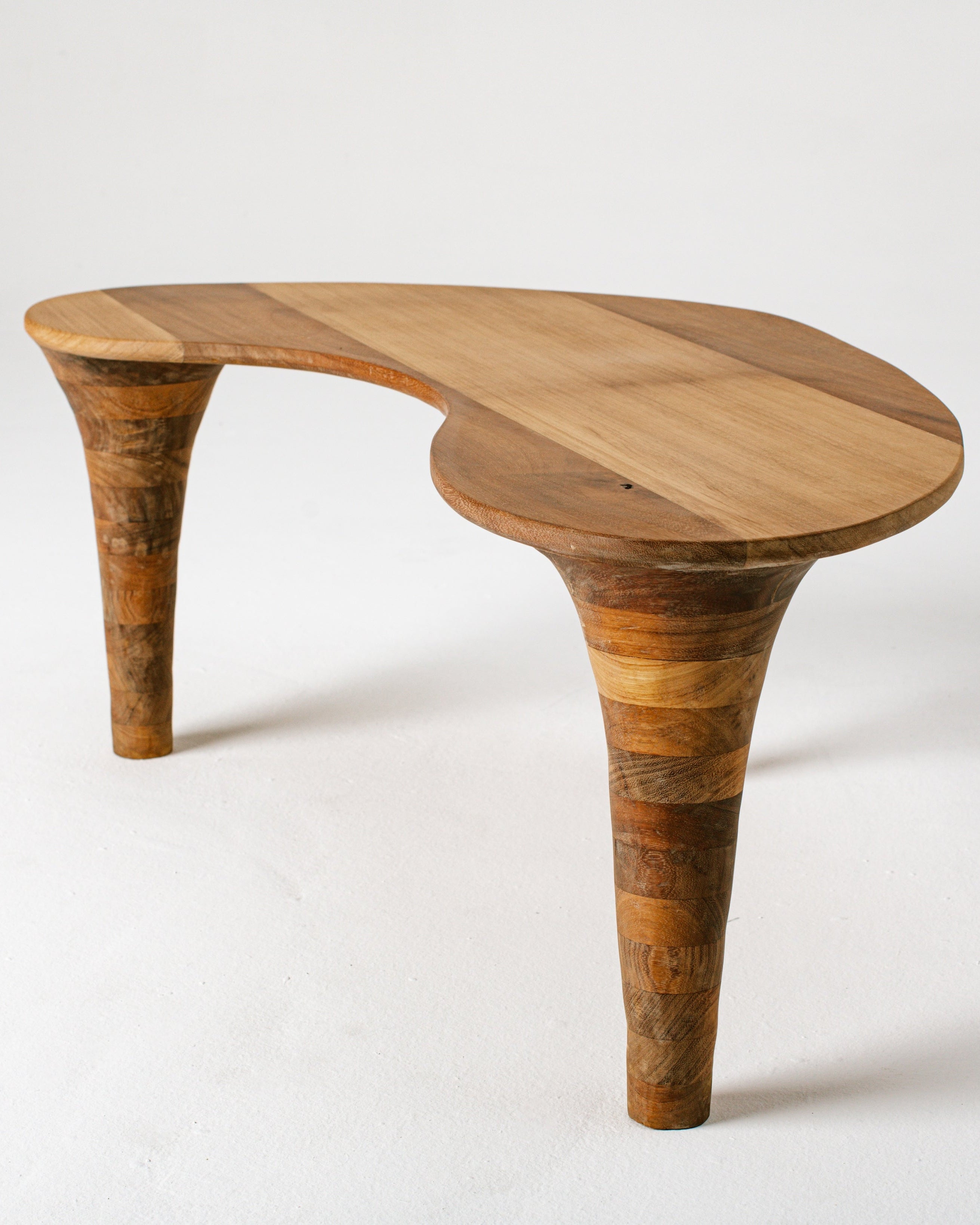 Curved organic wood coffee table with tapered cone legs detail