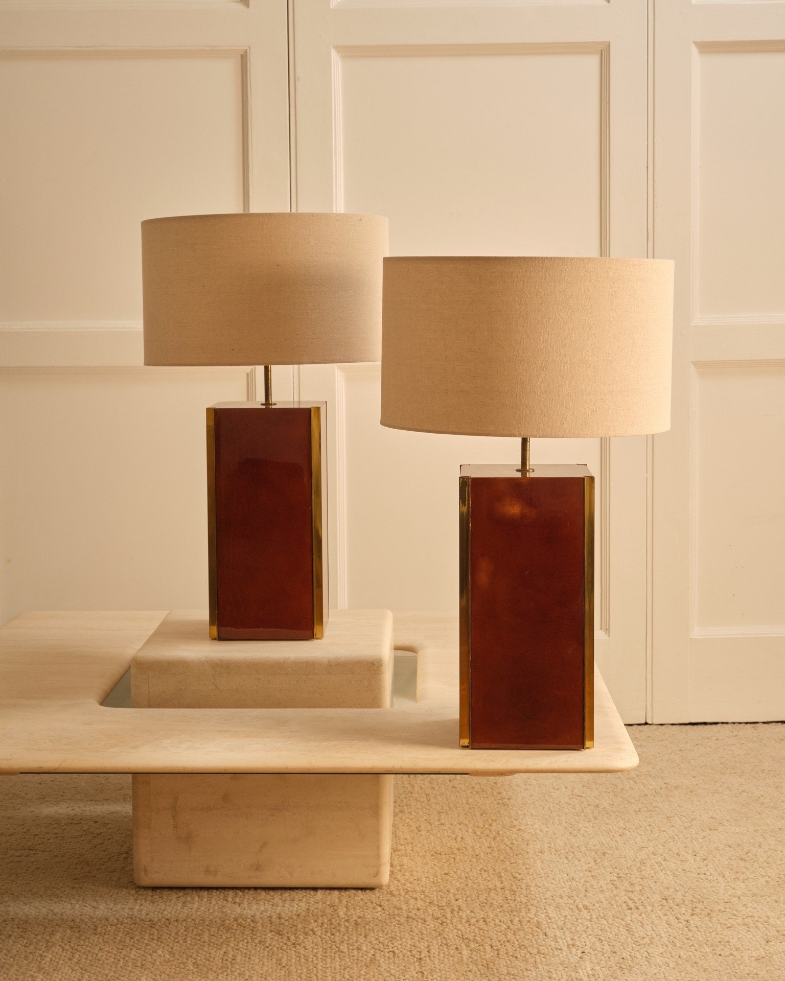 Travertine coffee table styled with amber glass table lamps
