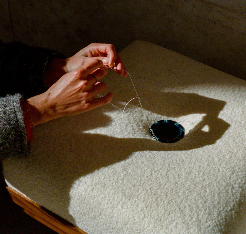 The Naos Bench — close-up of hand stitching on wool surface