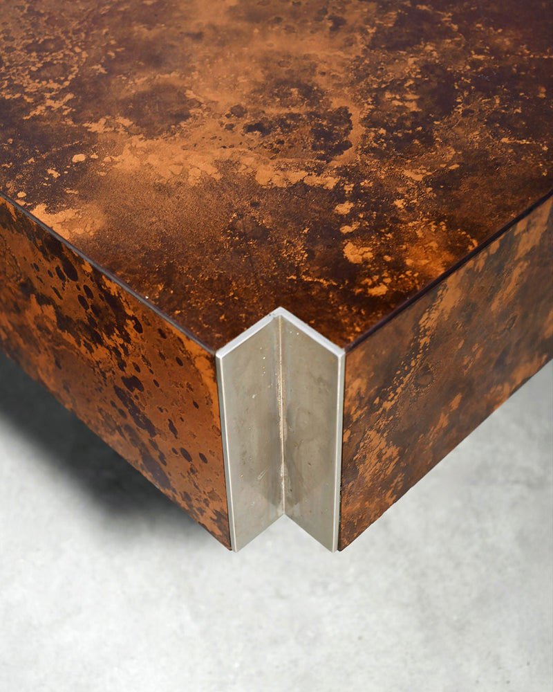 Corner detail of copper oxide coffee table showing weathered patina and clear acrylic edge