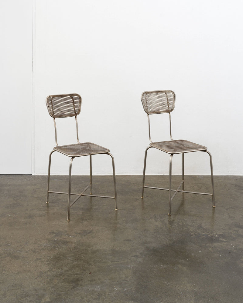 Pair of vintage perforated metal dining chairs with tubular frames