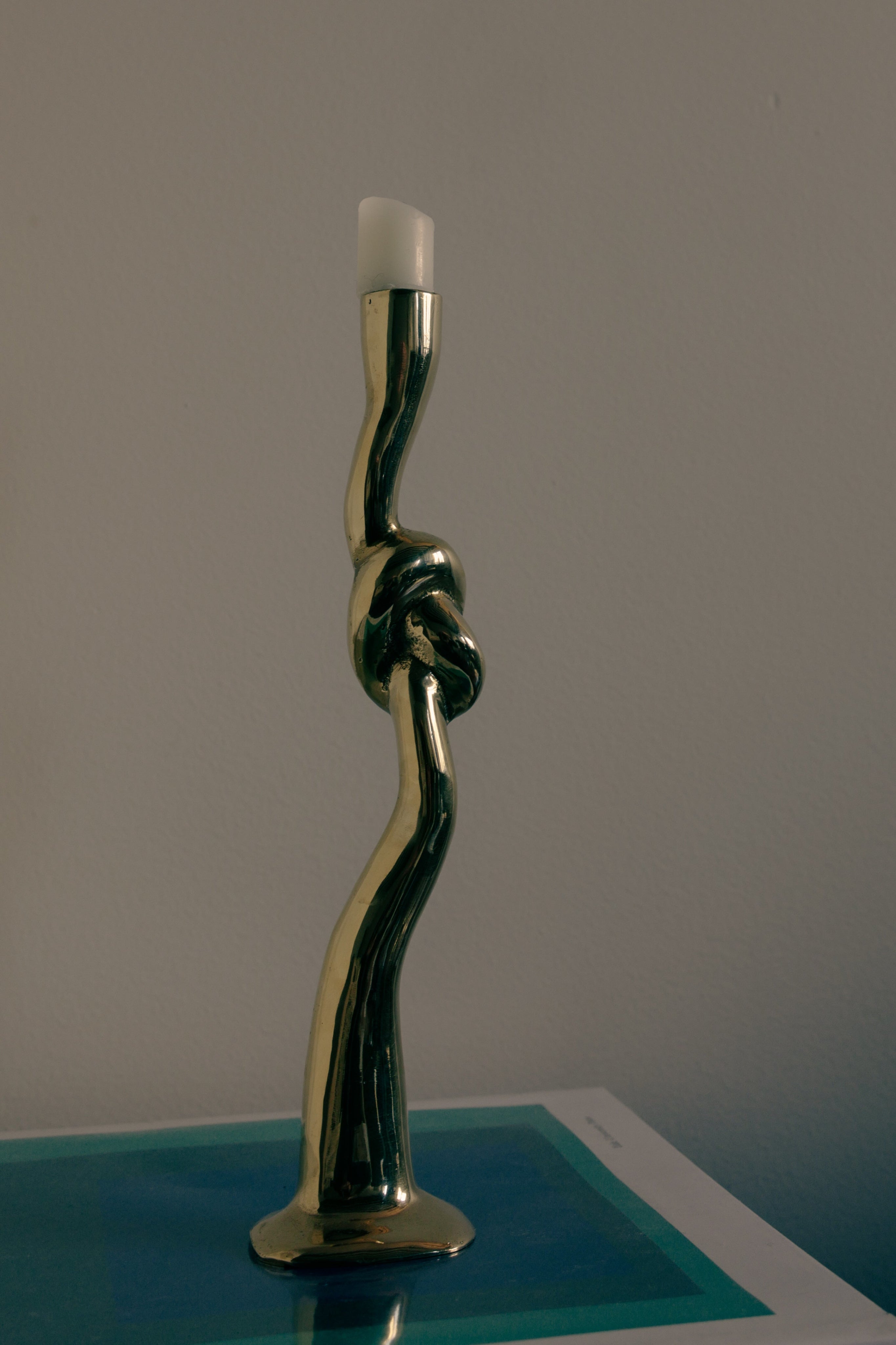 Fluid Knot Candlestick, Spain, c 1970s — back view on blue surface