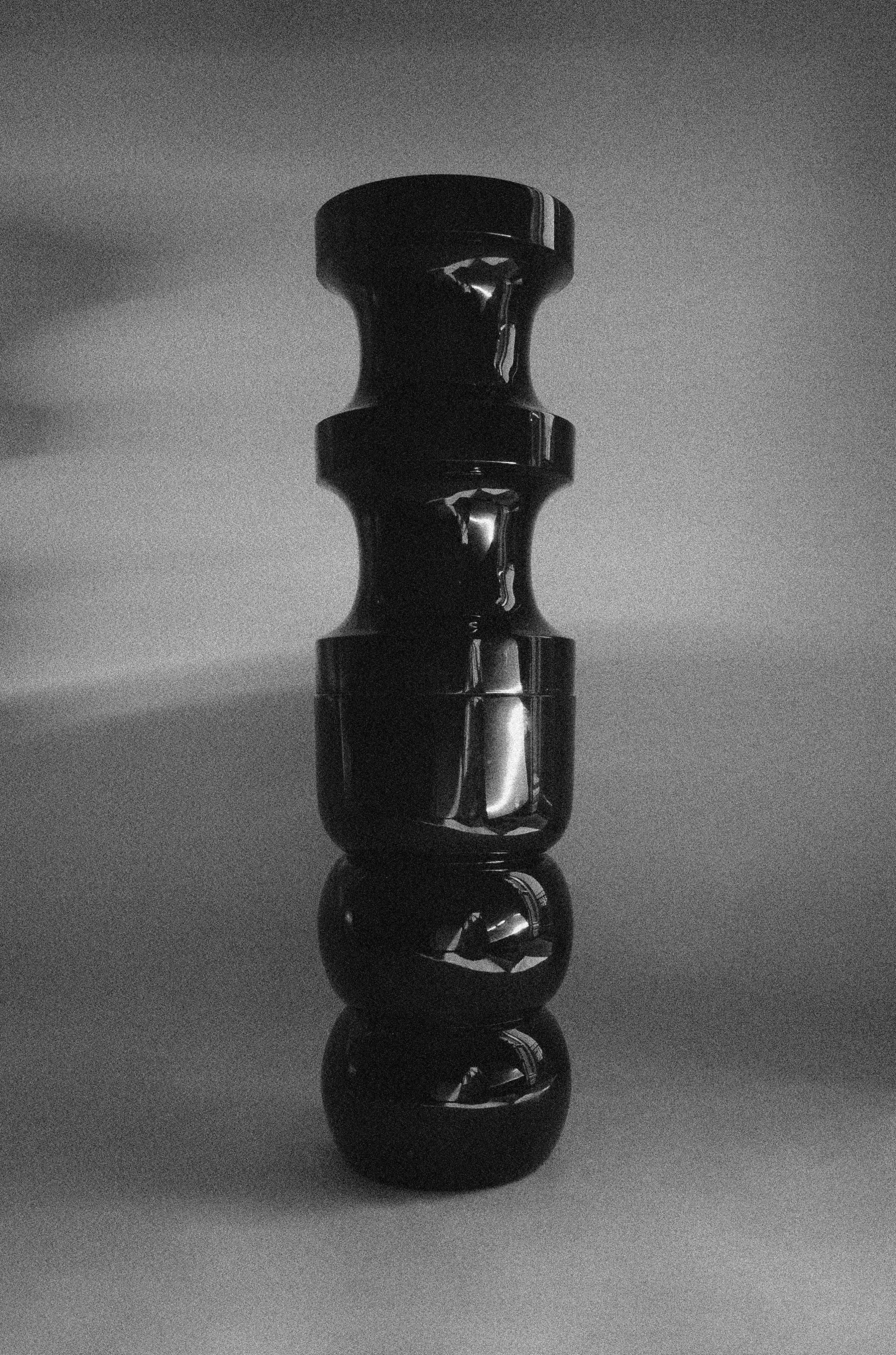 Chess' Stool convex in lacquer wood — top view of glossy black surface