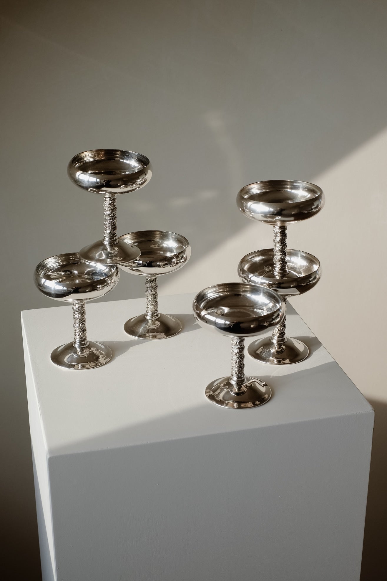 Set of 6 Silver Coupes — angled view on white pedestal with shadows