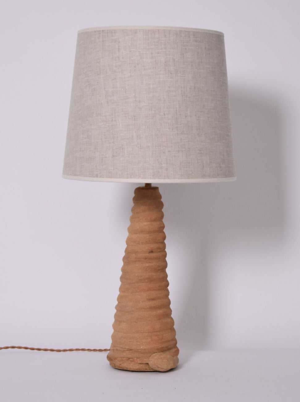 The "Teotihuacan" Green Ceramic Table Lamp, Barracuda Edition by Barracuda Interiors features a textured, cone-shaped green ceramic base and a light gray fabric shade, shown on a white background with the cord visible at the base.