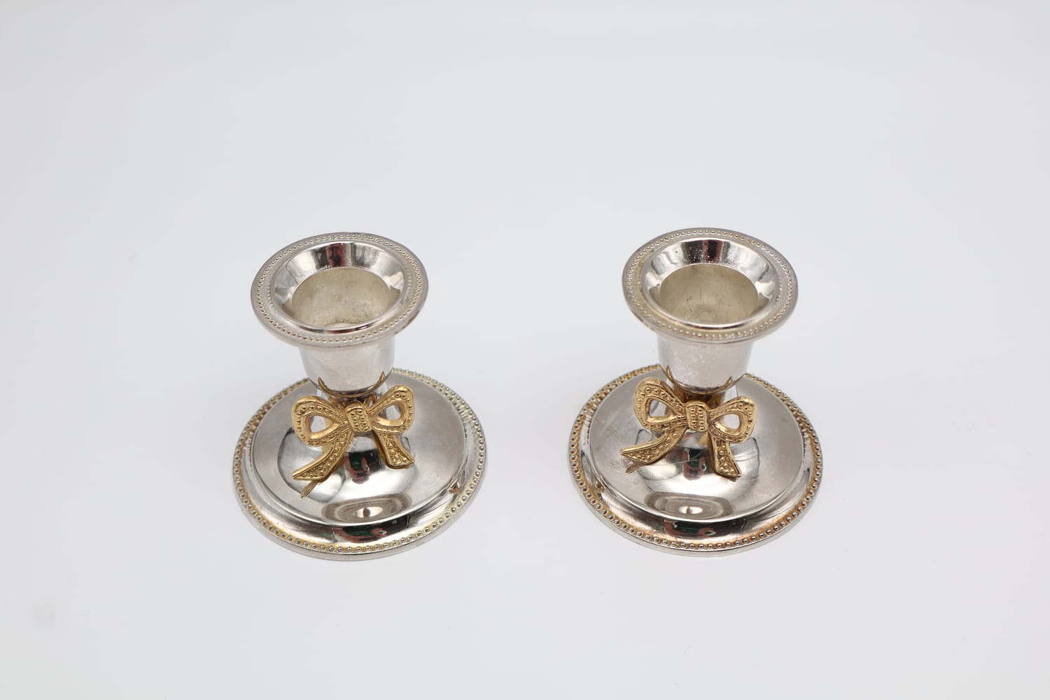 Pair of Vintage Silver-Plated Candlesticks with Gilt Bow Accents — side angle