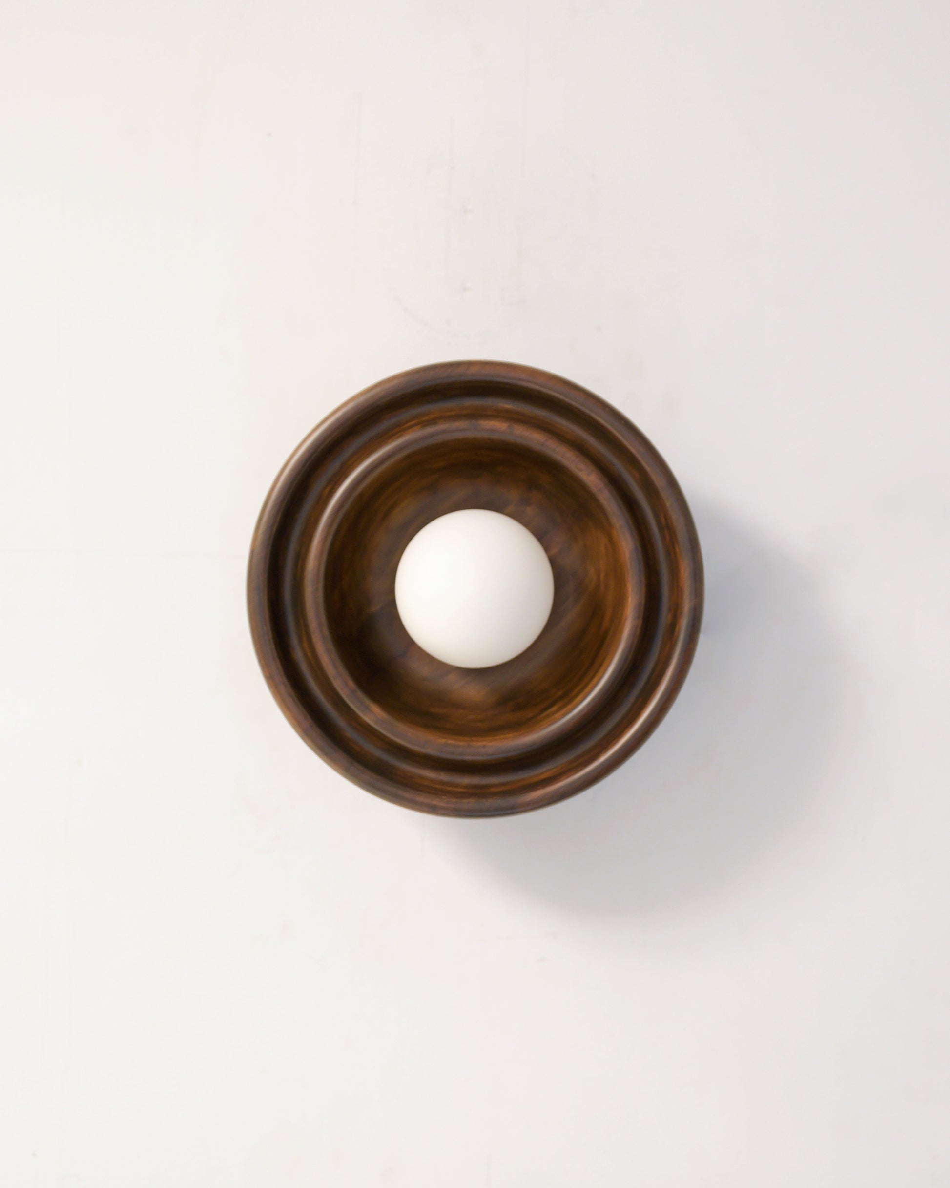 Discus XS Wall Light — top view of wooden base with white globe
