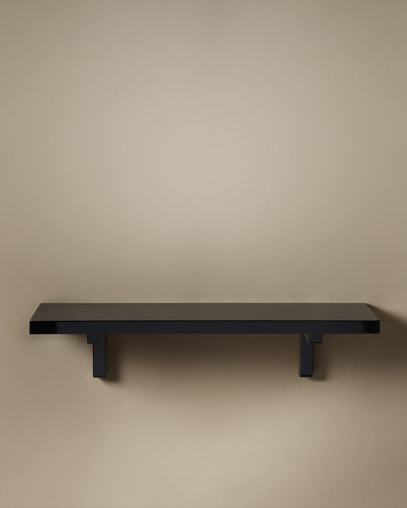 Black lacquered floating shelf with geometric bracket supports