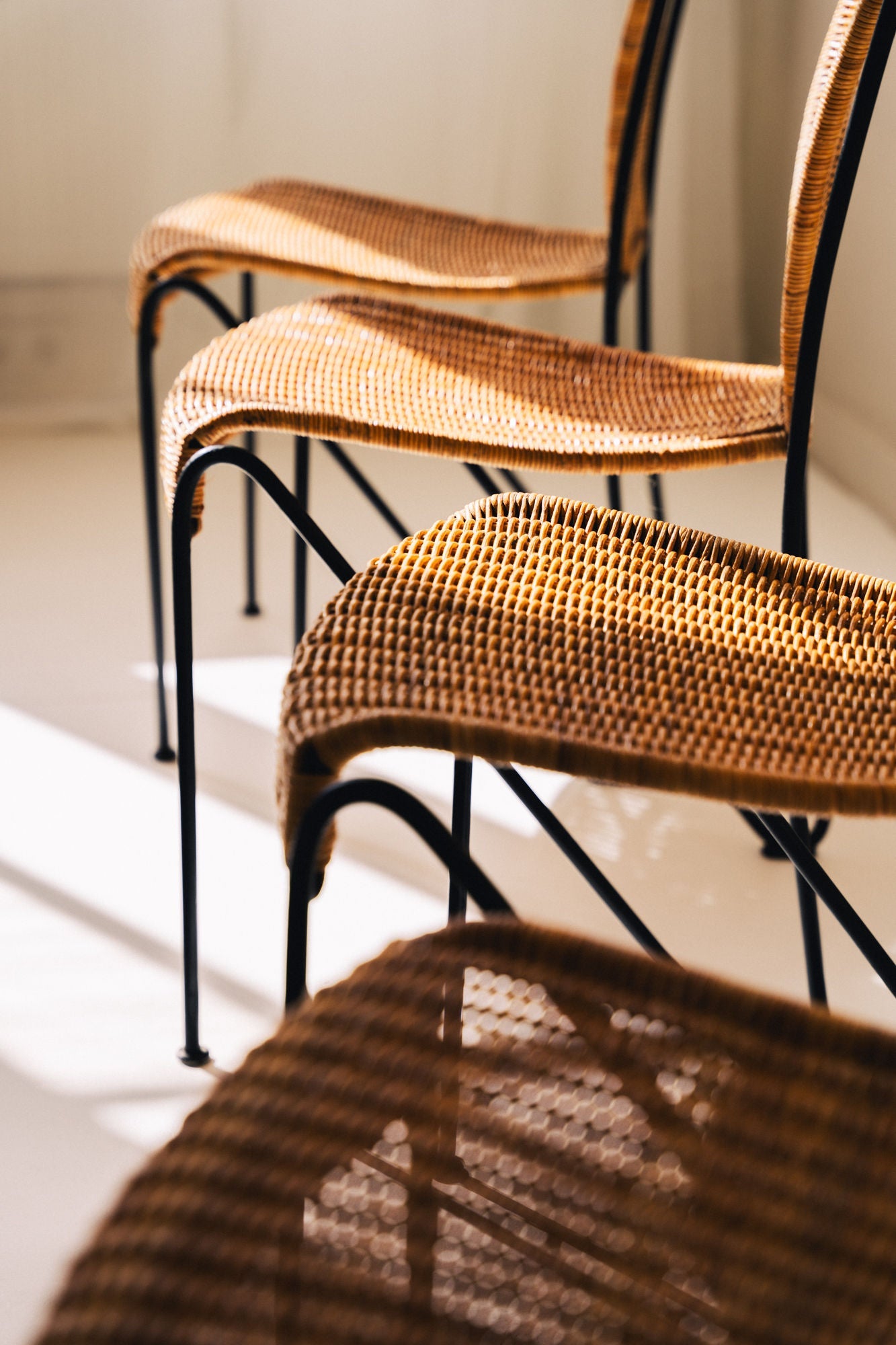 Stacked 1950s wicker chairs showing woven cane seat texture detail