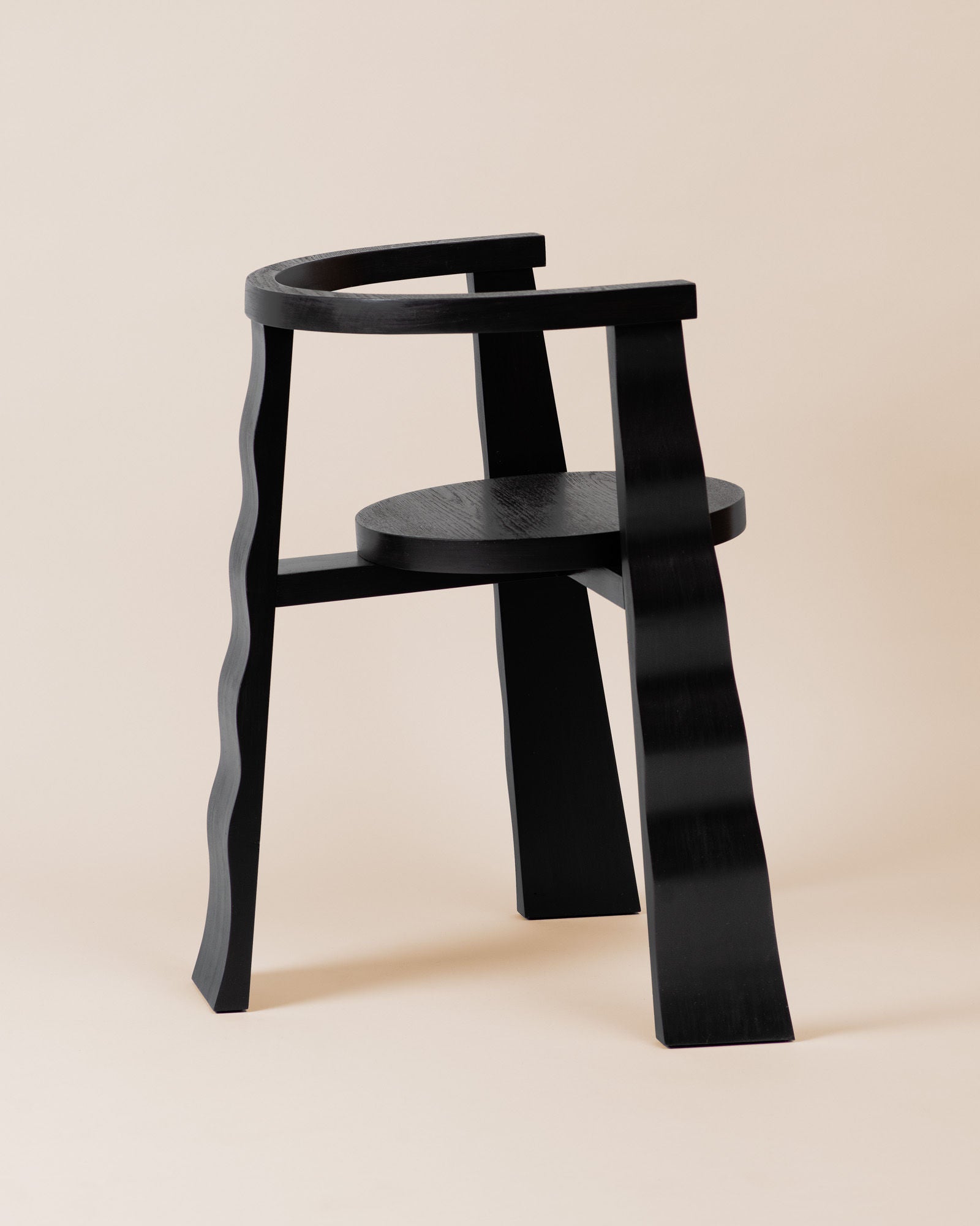 Black wooden Puro chair with curved legs and circular seat detail