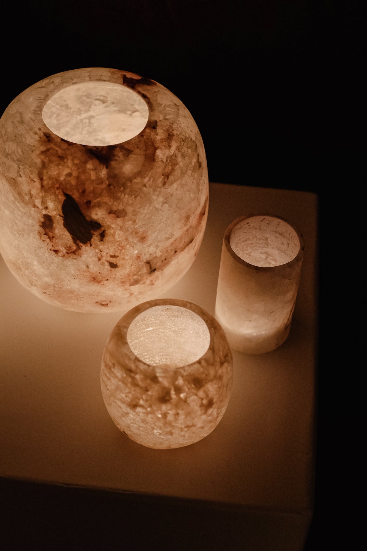 Alabaster Candle Holder — side angle with warm glow on white surface