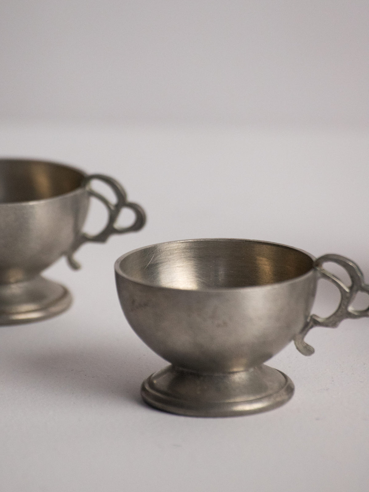 Six Footed Pewter Punch Cups, Triple-Loop Handles, Sweden 1977 — lifestyle setting