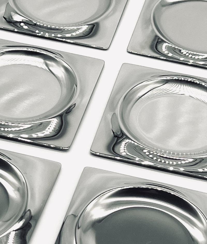 Close-up detail of vintage stainless steel coasters grid pattern
