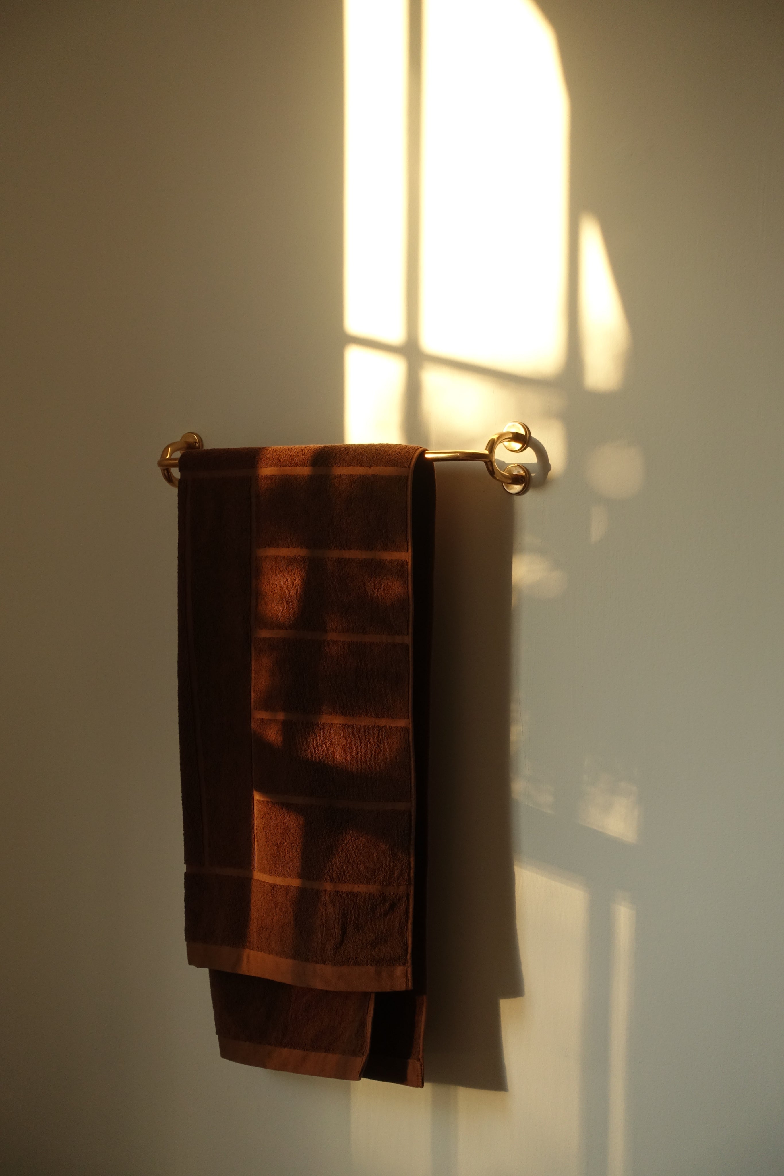 FAUNA Towel Bar (2 sizes) — mounted on wall with brown towels