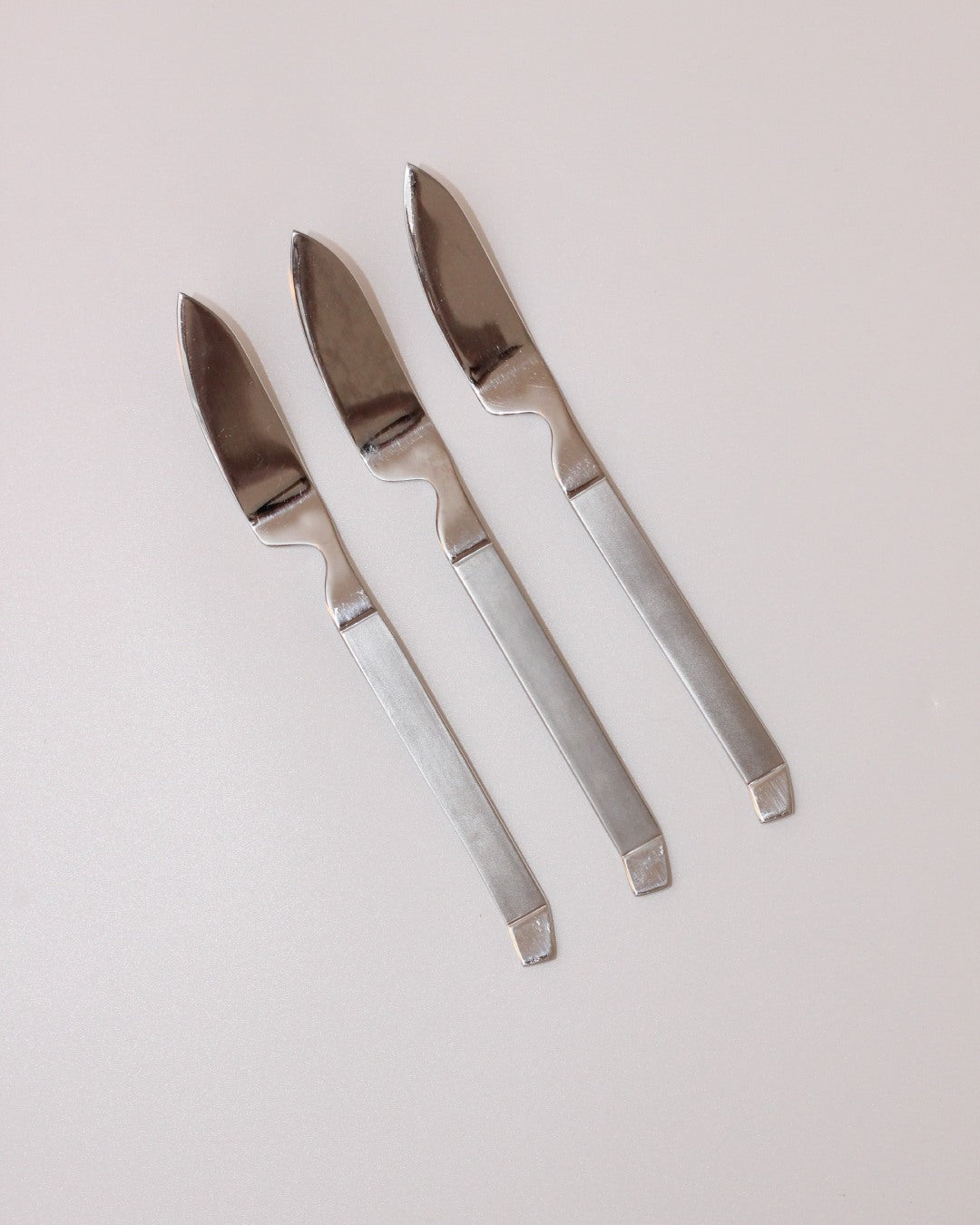 Stainless Steel Cutlery Set — side angle of three knives on light surface