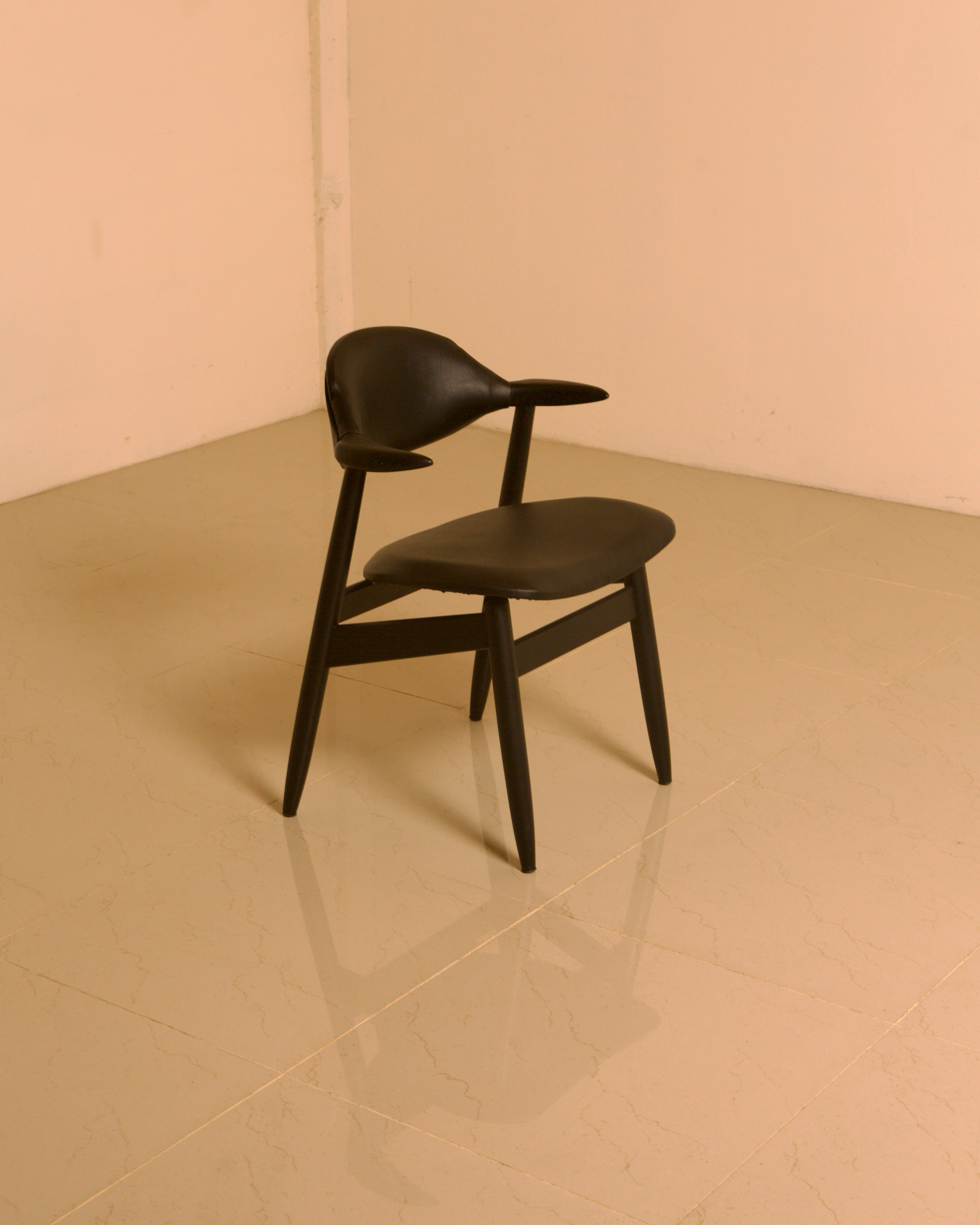 Dutch "Buffalo" Armchair in Wood and Black leather, 1960s — back view on polished floor