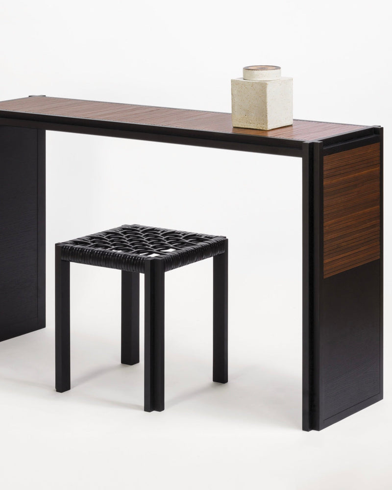 Structura console with black woven stool and ceramic vessel