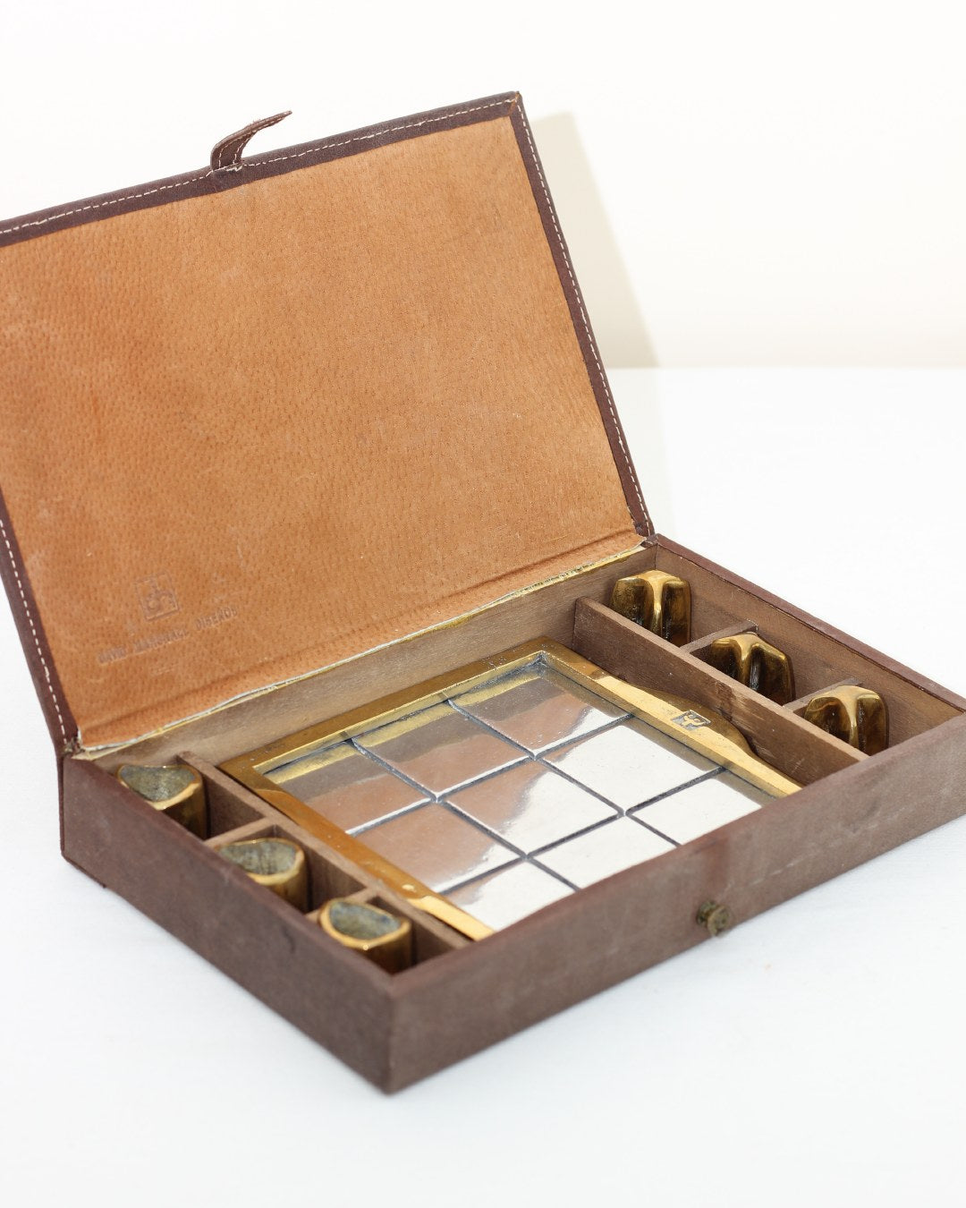 TRES EN RAYA BRUTALISTA — side angle of handcrafted game box with brass details