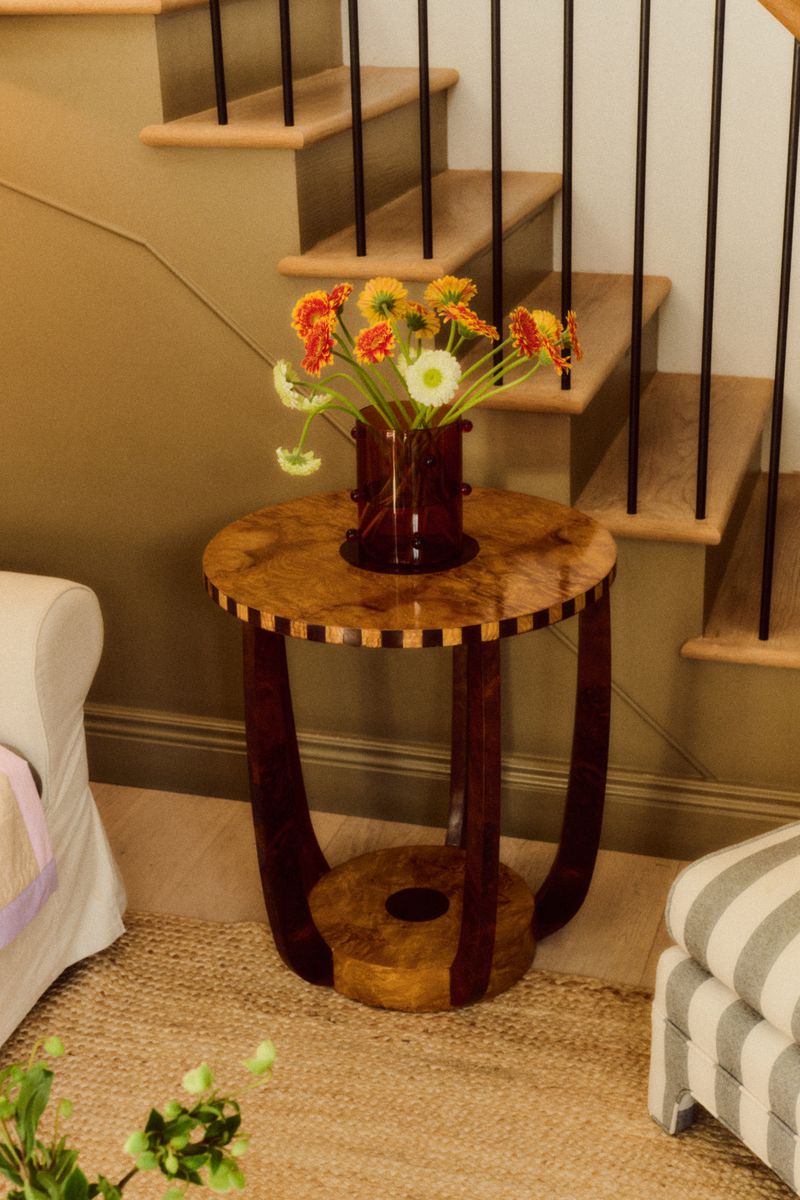 Roman' Burl Side table — side angle with flowers on top