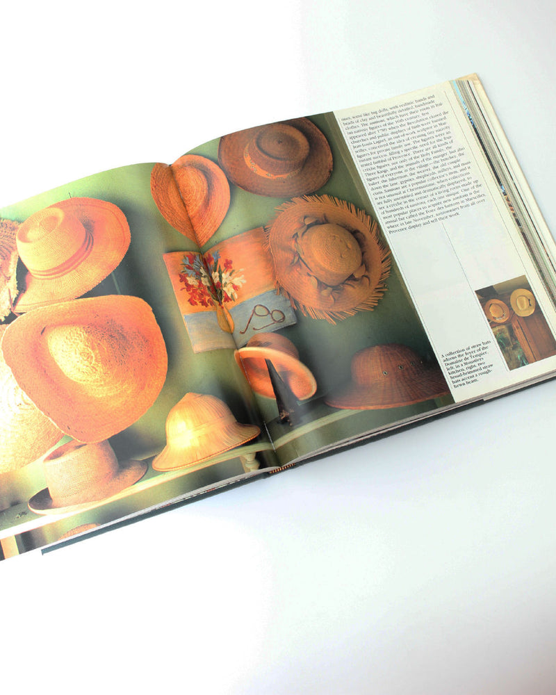 French Country Book — open view of straw hats on green background