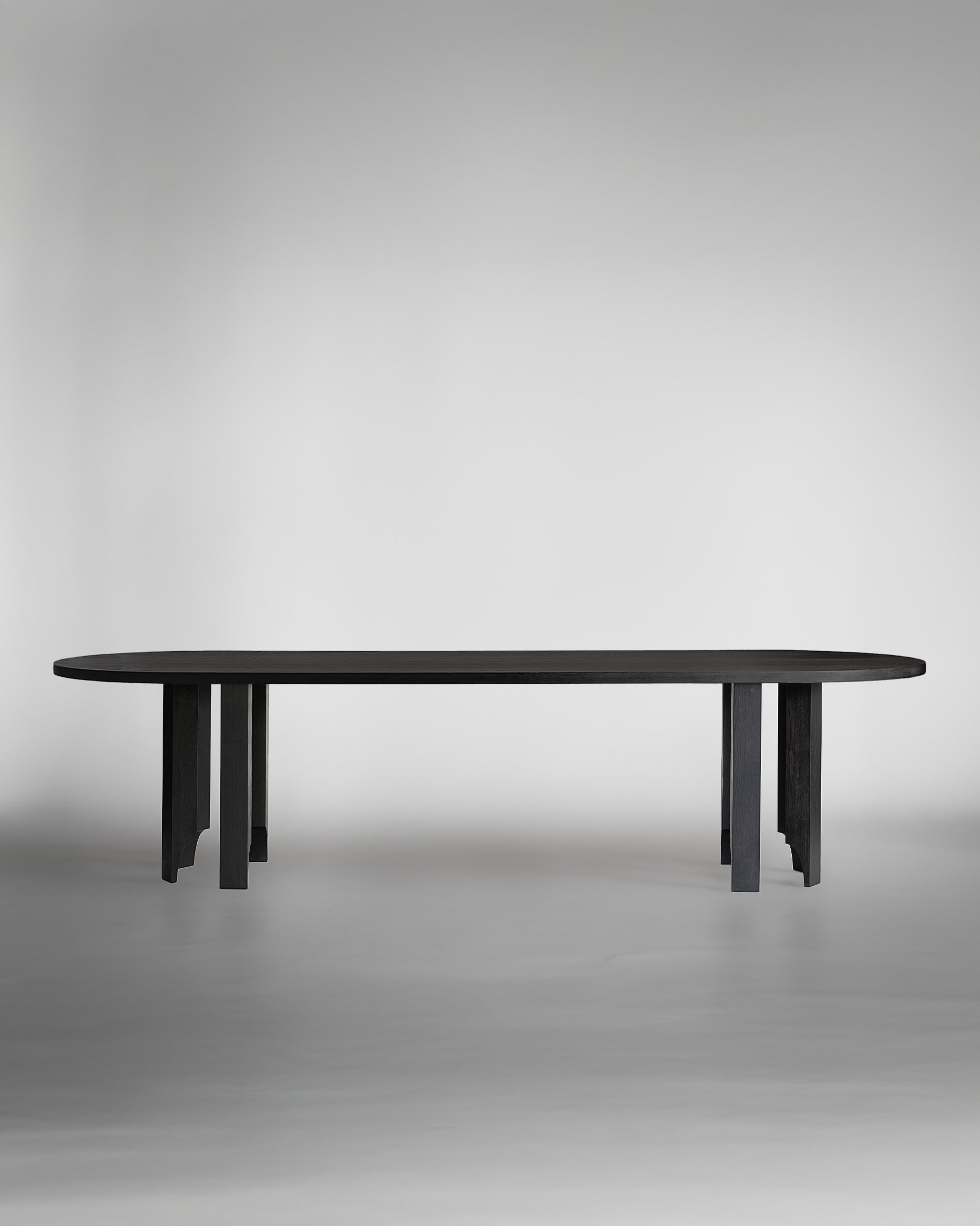 The Acer Capsule Table by Mokko features a minimalist, modern design with a solid European oak build, six legs, and an elongated oval top. Photographed on a light gray background, its clean lines highlight its customizable and timeless appeal.