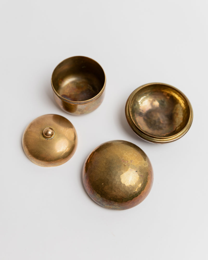 Four brass tins disassembled showing lids and bowls detail