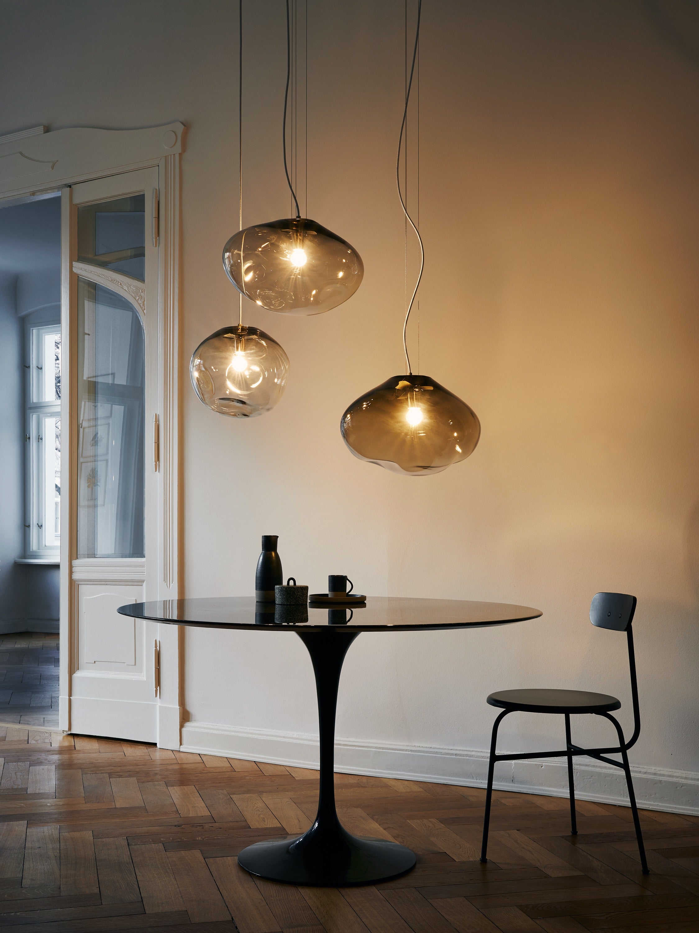 HAUMEA AMORPH pendant - size M (L: 32cm), L (L: 40cm), XL (L: 47cm) — hanging above round black dining table in modern settin
