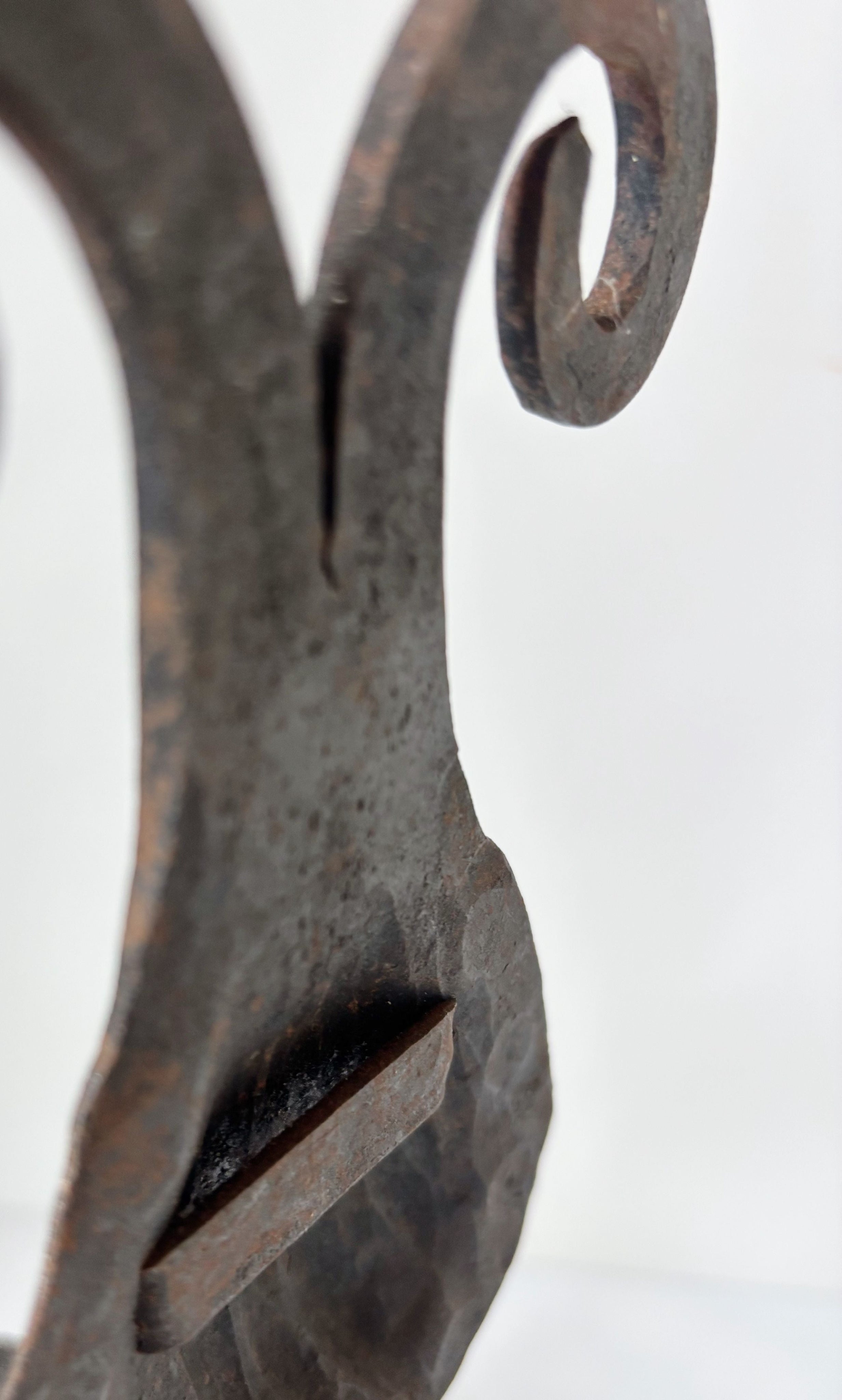 Close-up detail of hand-forged iron wall candleholder curves