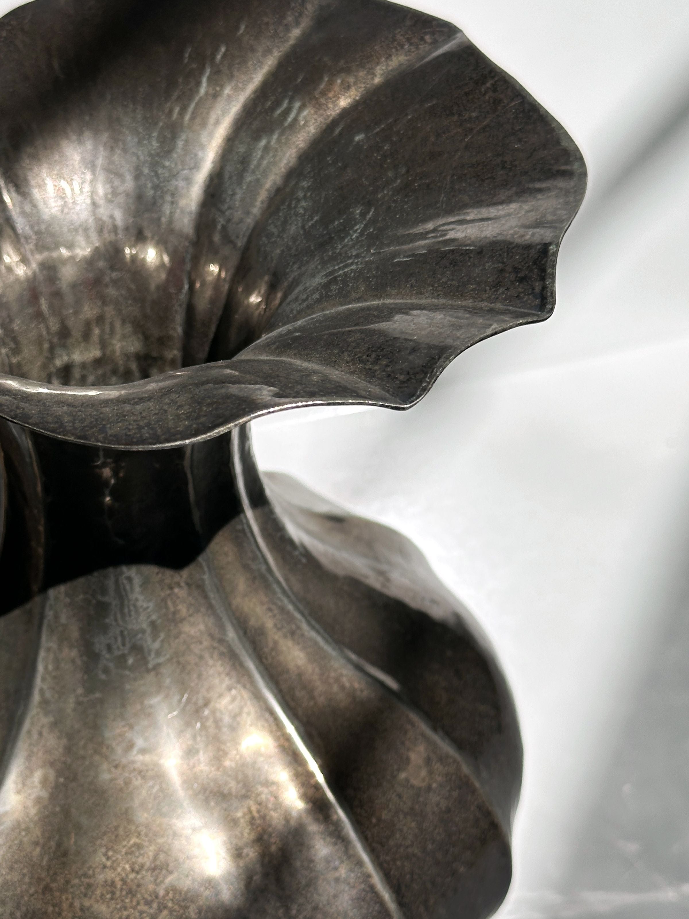 Close-up detail of silver-plated Art Nouveau vase curved edges