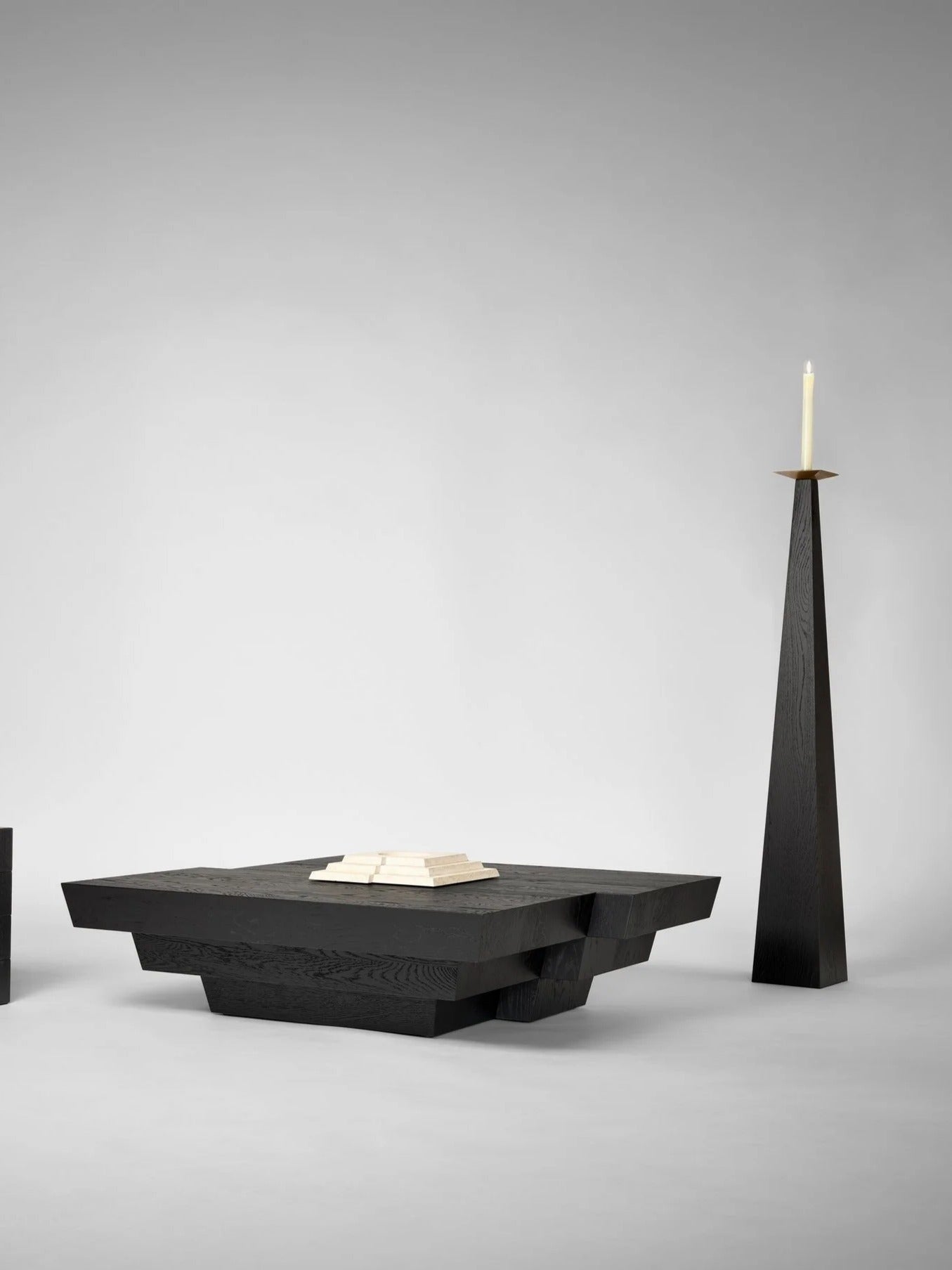 Taes Candle Holder — tall black wooden holder beside low black table