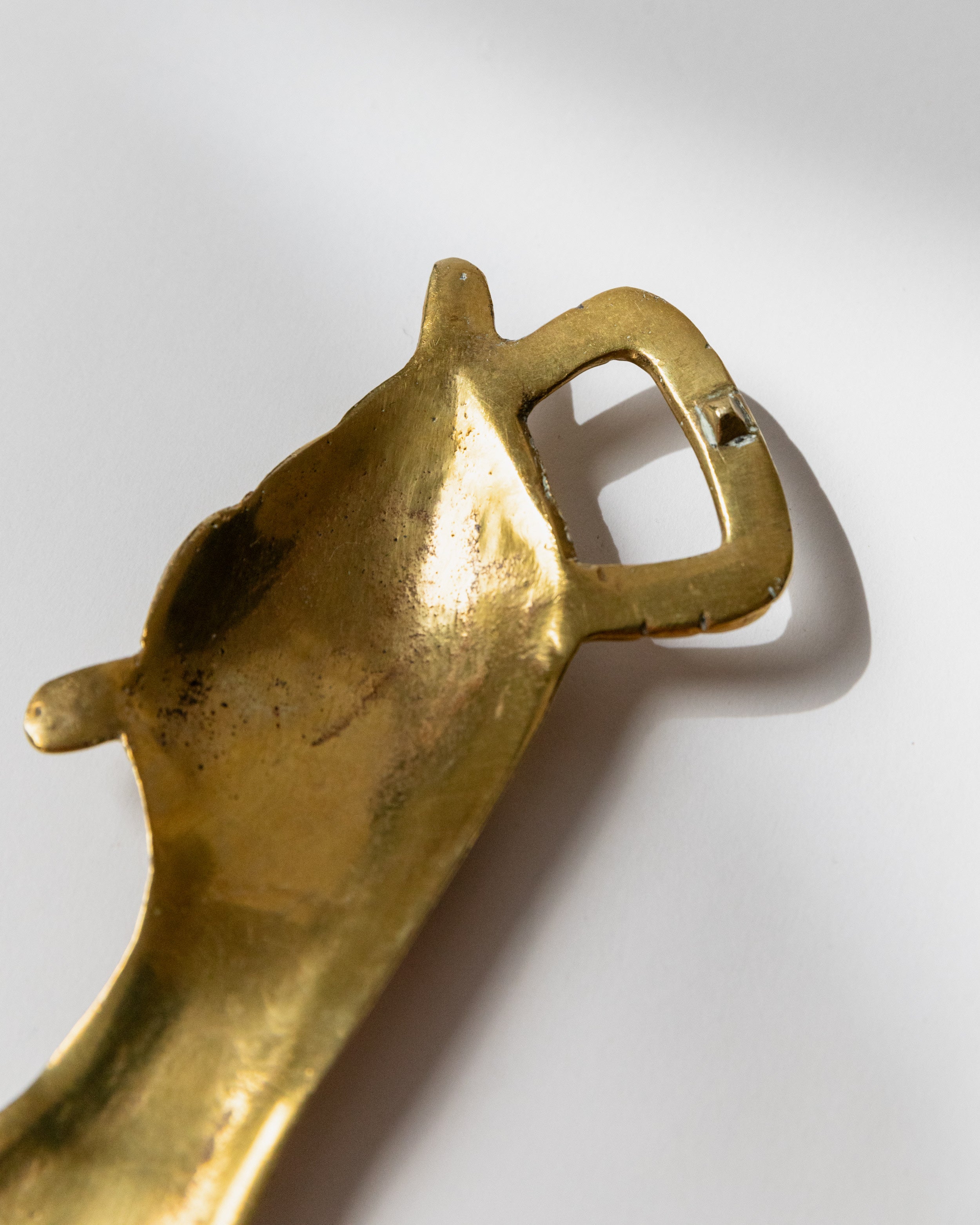 Close-up detail of brass bottle opener handle and mechanism