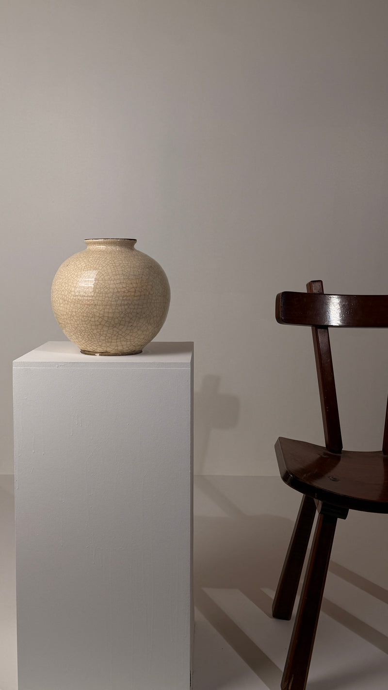 Important crackled white ceramic vase, France, circa 1930, Art Deco period — close-up on pedestal beside wooden chair