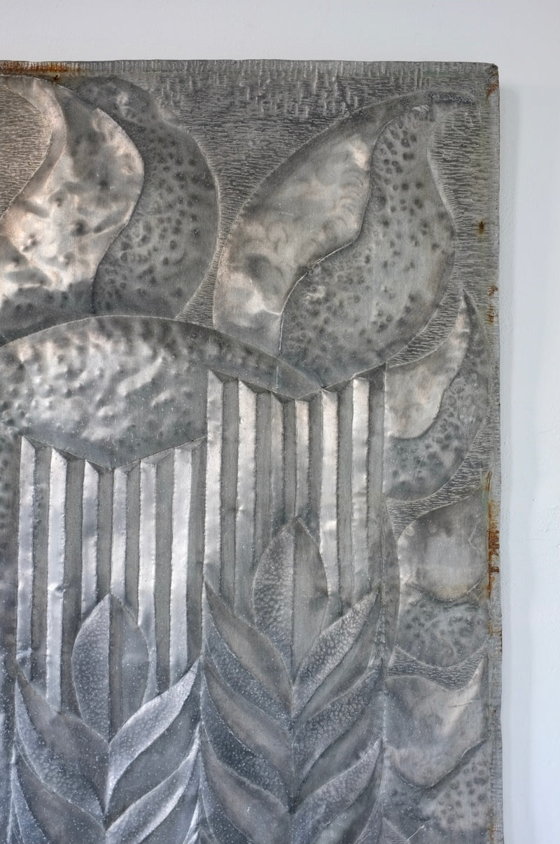 Brutalist metal relief sculpture detail showing textured botanical motifs