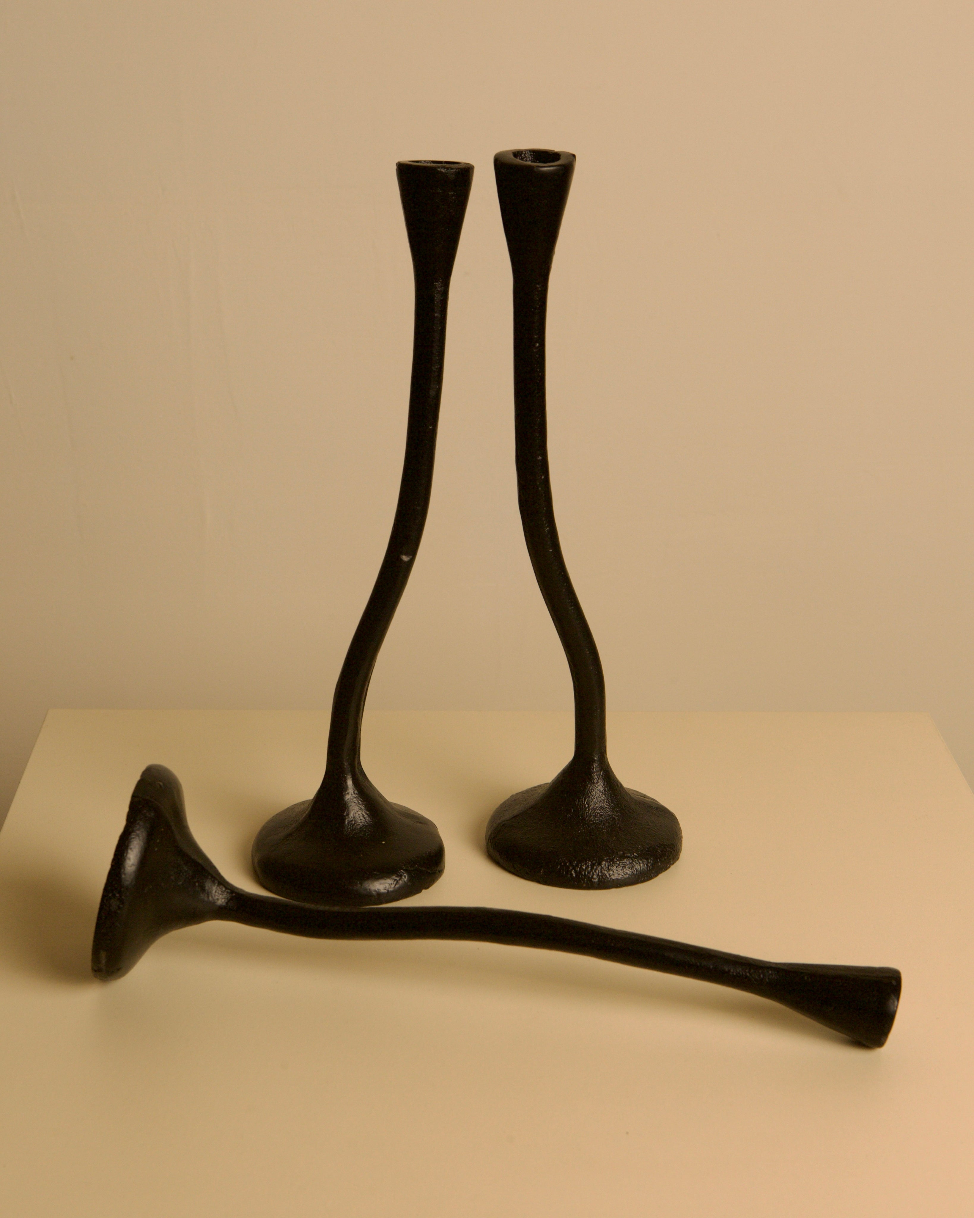 Set of 3 "Twisted" Candleholders in Black Cast Aluminum, 80s — side angle showing three candleholders on a neutral background