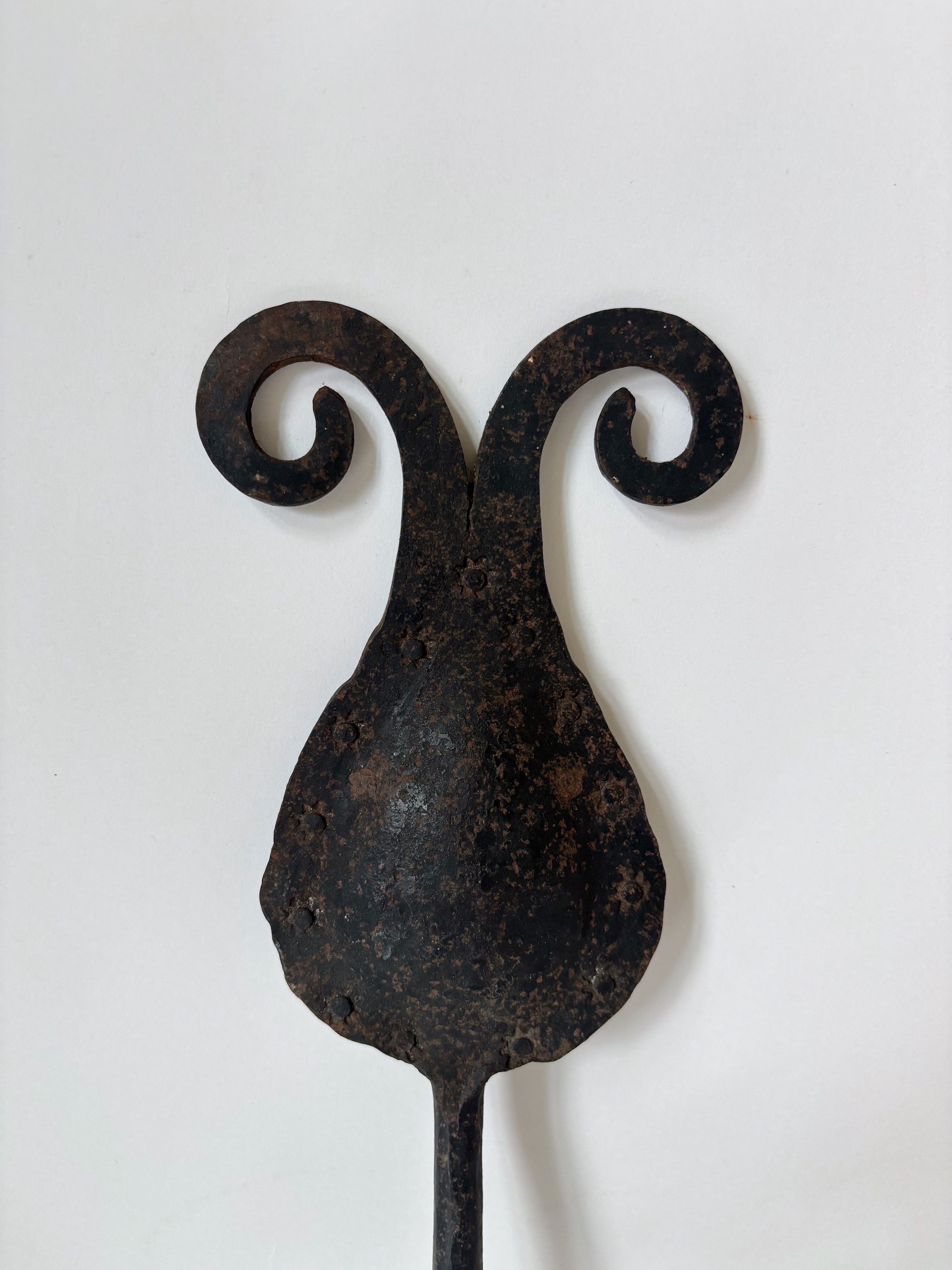 Hand-forged iron candleholder with curved scrollwork arms detail