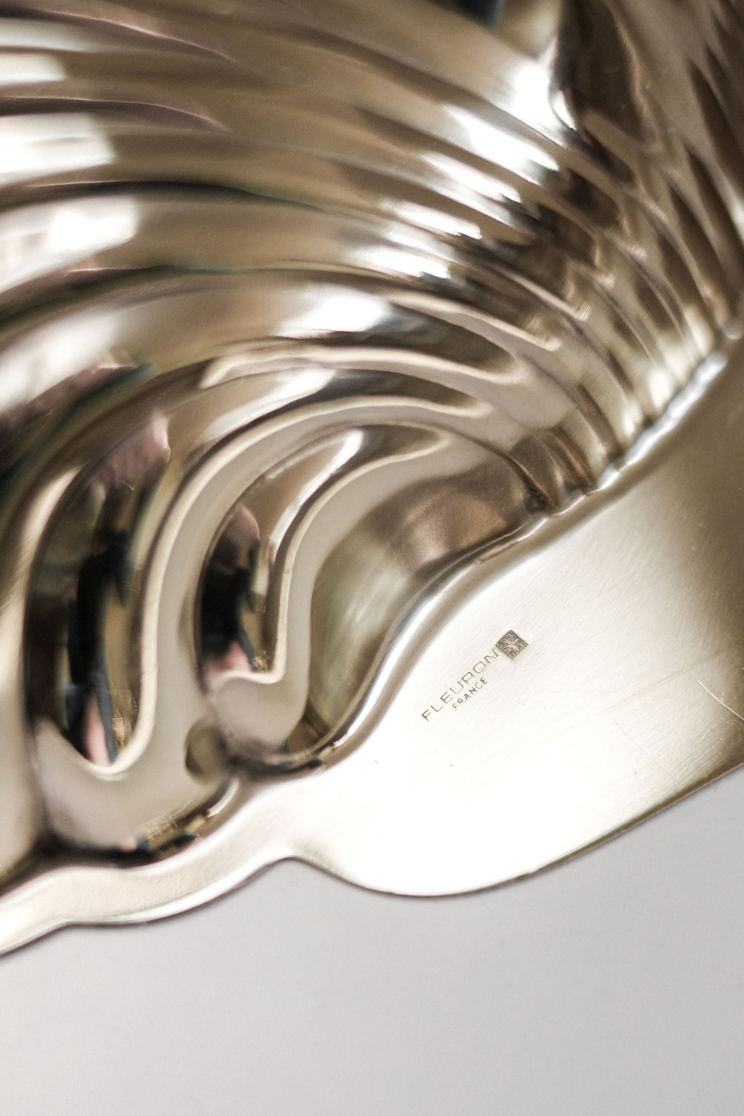 Medium Shell Shaped Vide-poches — side angle of polished metal surface